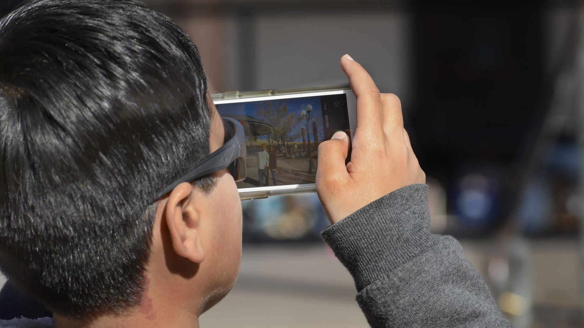 A boy takes a photograph with his smartphone in Santa Fe, New Mexico.
