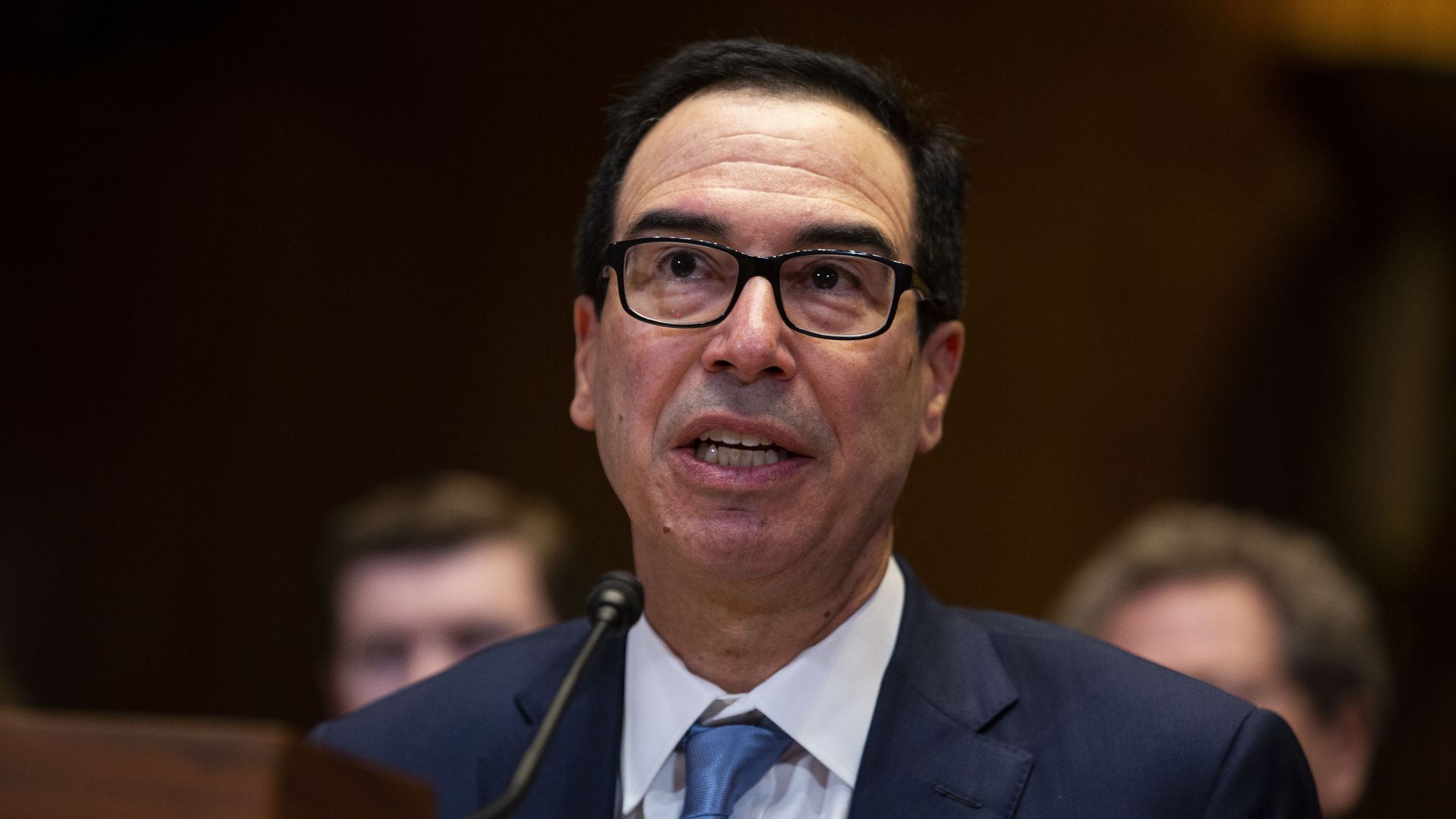 In this image, Steve sits and speaks into a microphone at a committee hearing.
