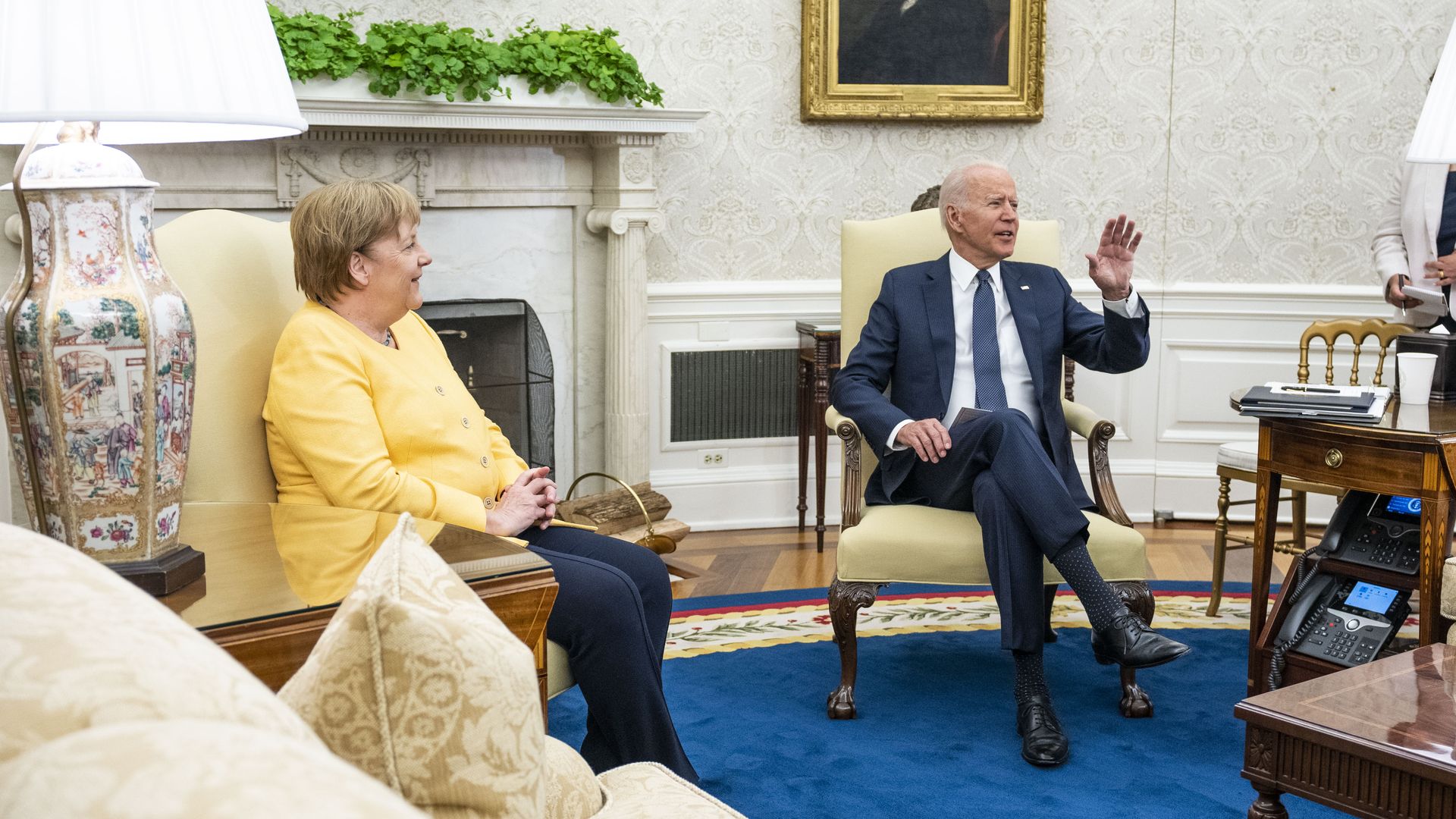 President Biden is seen sitting with German Chancellor Angela Merkel in the Oval Office.