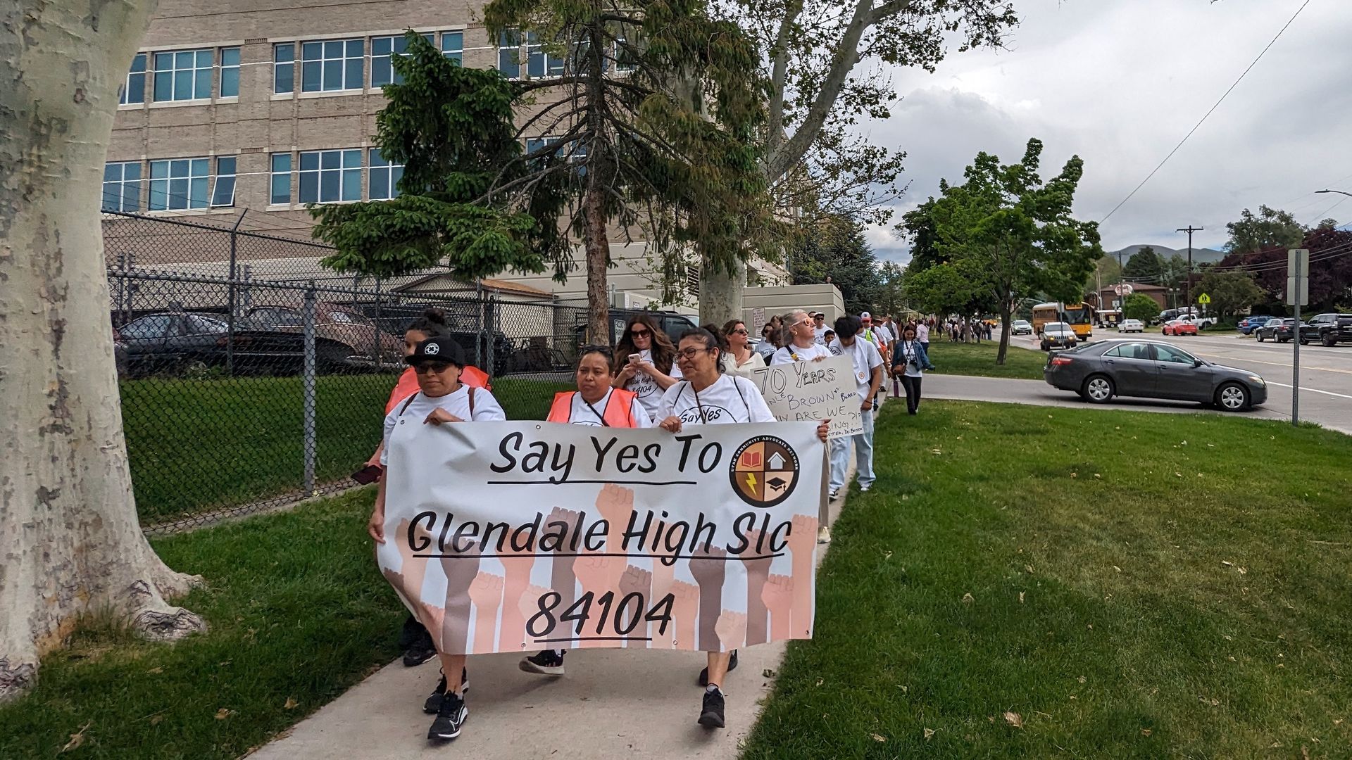 High school students and families walk with a sign that says "Say yes to Glendale High School"