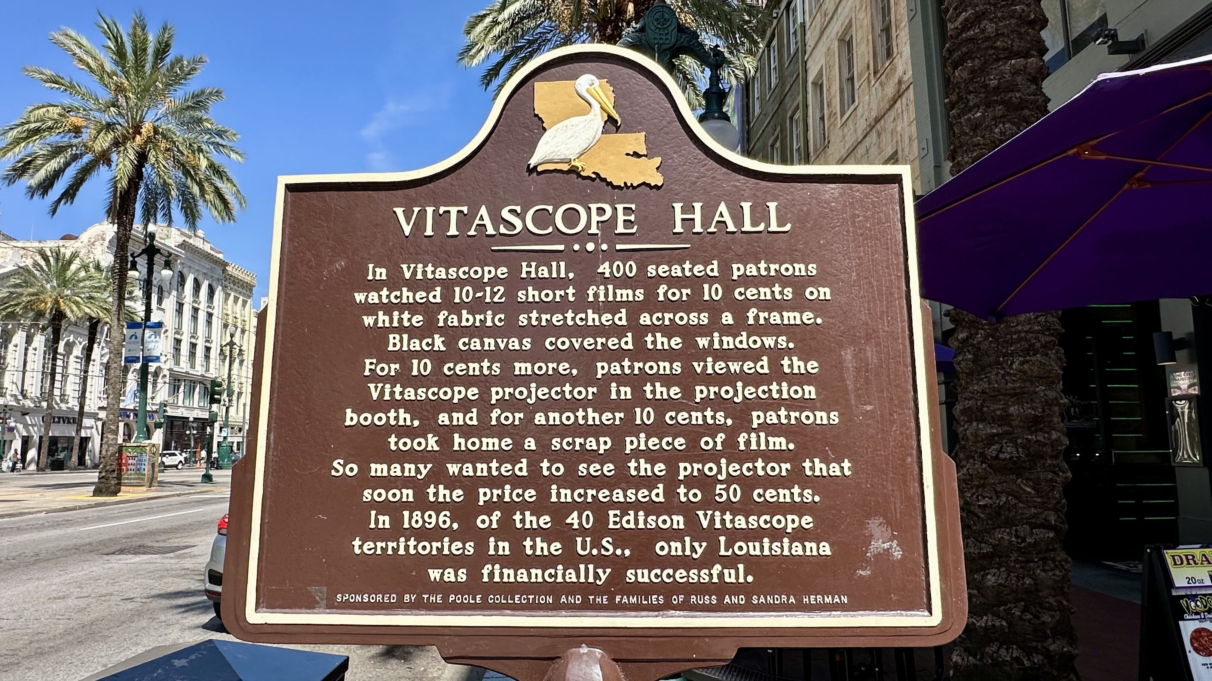 Brown historical marker titled Vitascope Hall with a pelican and Louisiana map emblem, describing early film screenings in Louisiana with details on pricing and popularity in 1896.