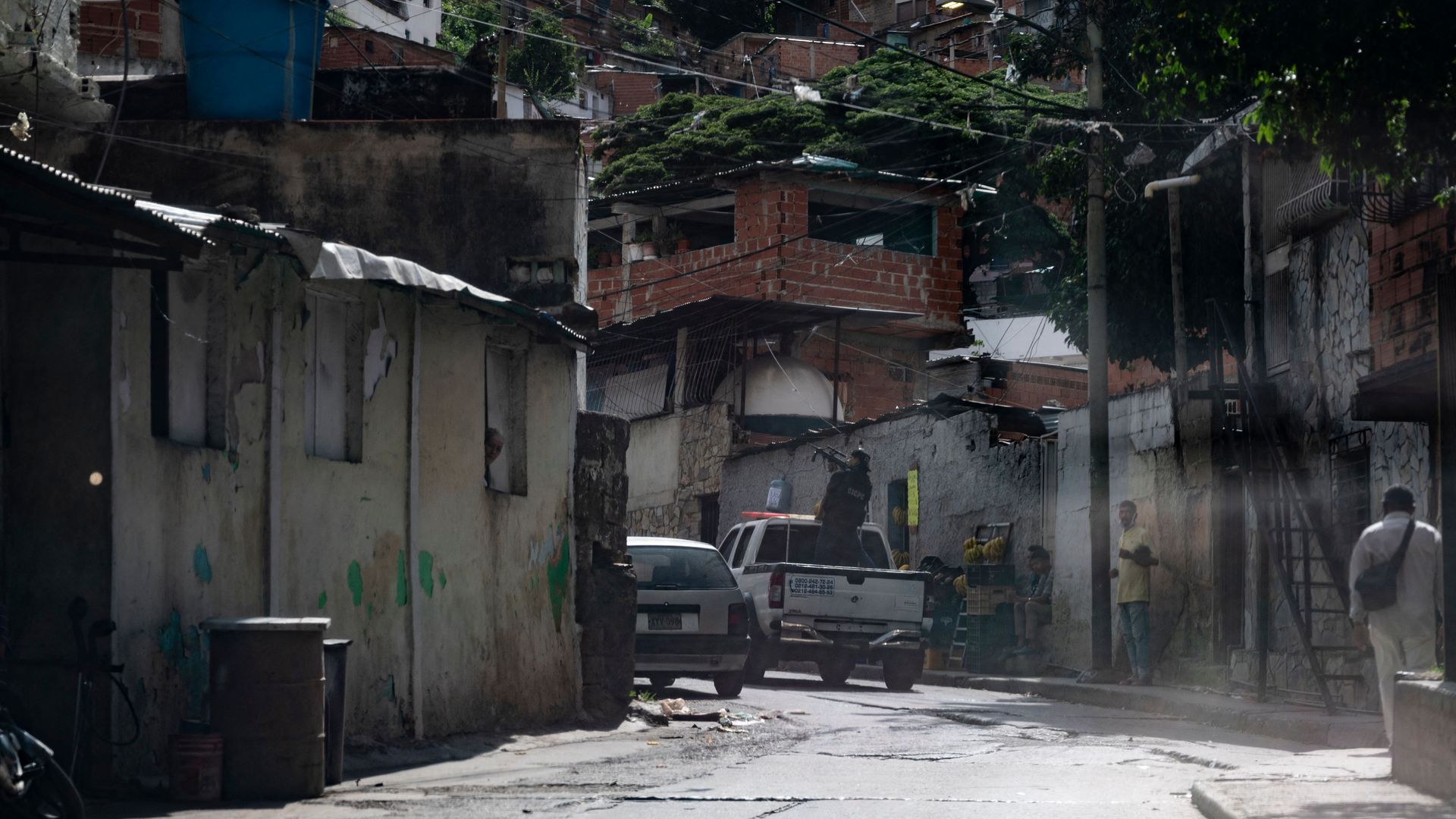 A member of the Scientific, Criminal and Forensic Investigations Corps (CICPC) aims his sub-machine gun while entering a Caracas neighborhood.