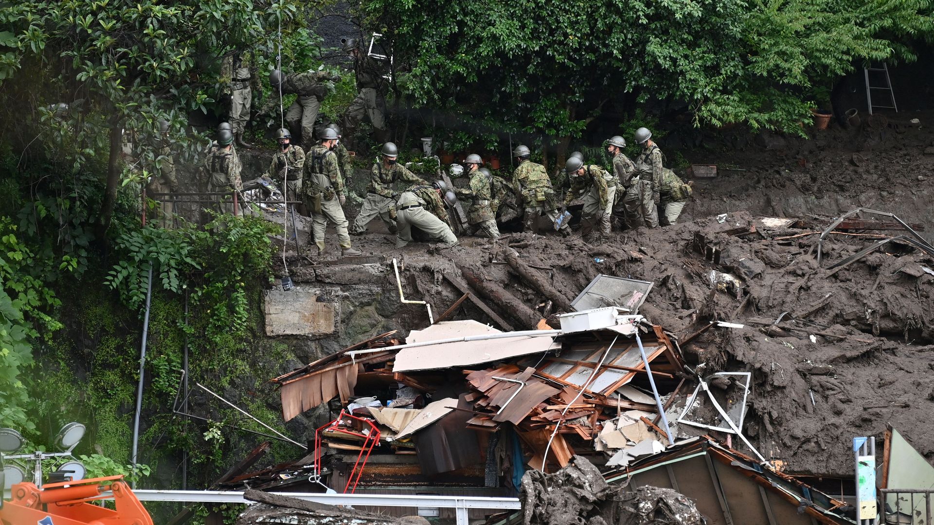 Members of Japan's Self-Defense Forces sift through mud and debris as they search for missing people at the scene of a landslide in Atami, Shizuoka Prefecture, on July 5
