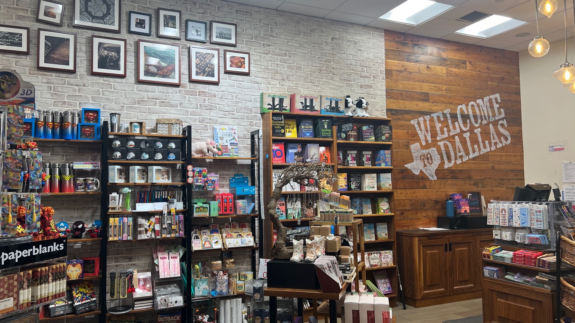 A bookstore with books on stands and a "Welcome to Dallas" sign