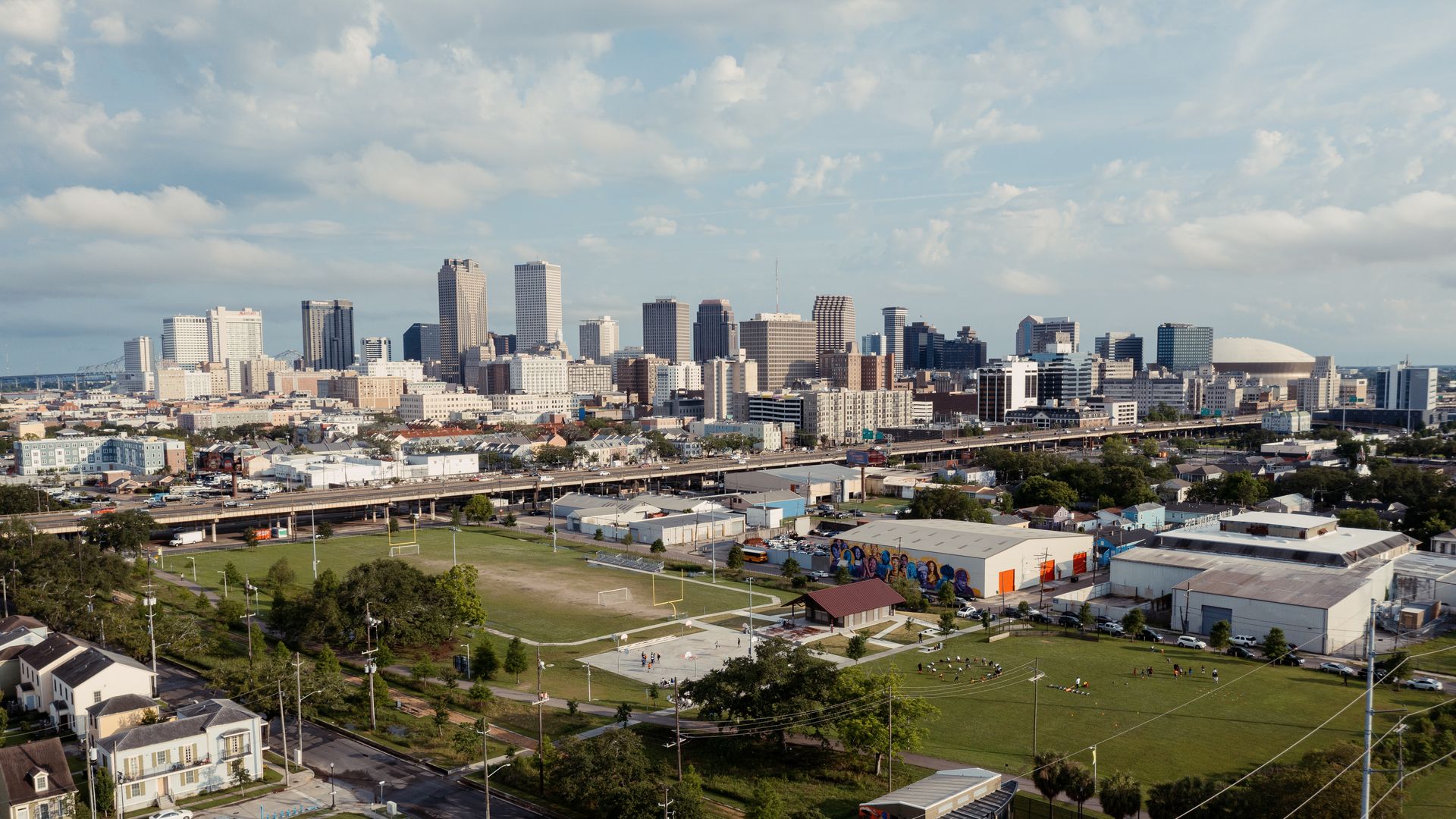 A skyline view of New Orleans from the perspective of the Lafitte Greenway. The Crescent City Connection is at far left, and the Superdome is at far right.