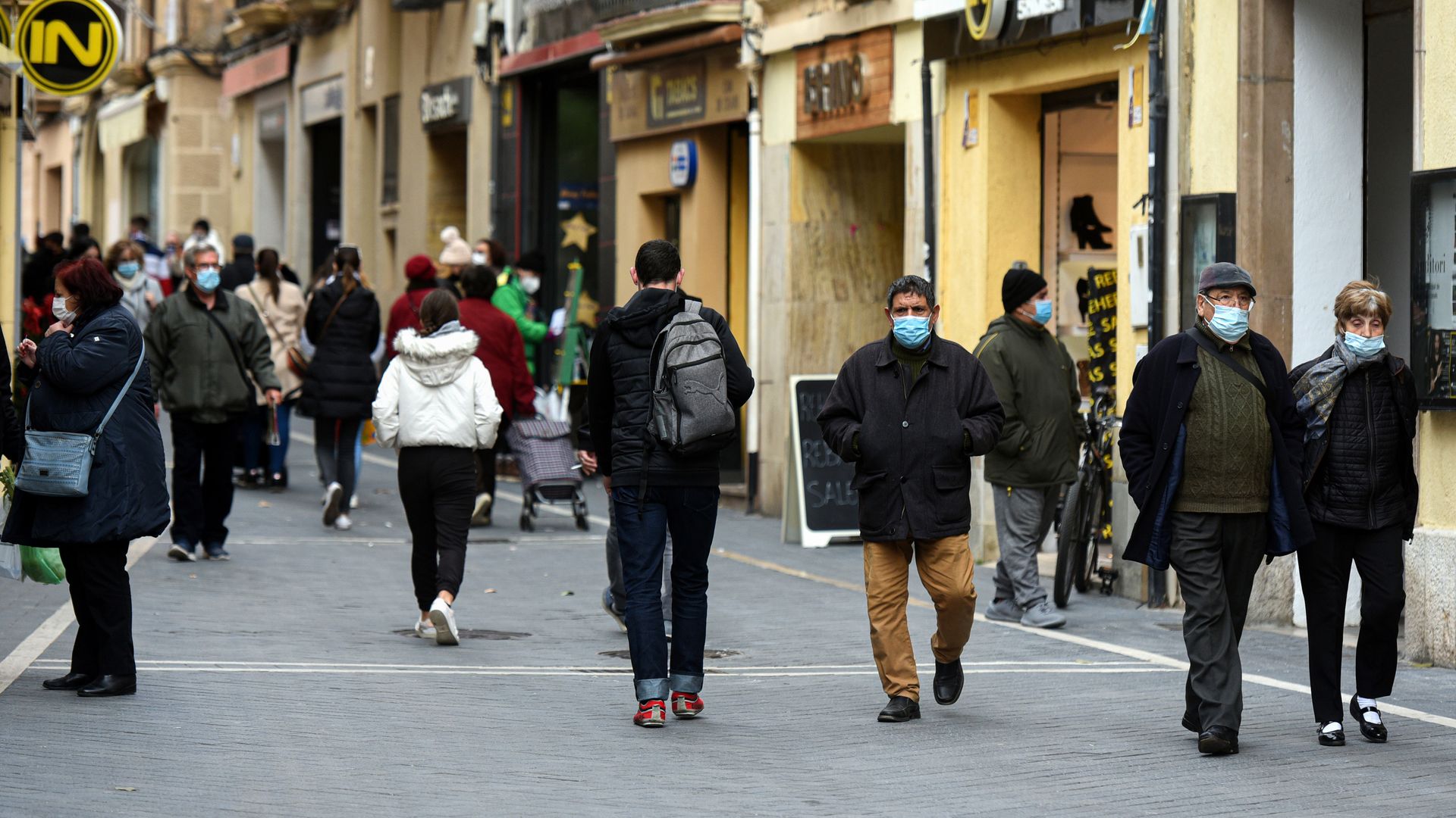 eople wearing face masks as precautionary measures against the spread of covid-19 are seen walking along a commercial area at the Vendrell Tarragona.