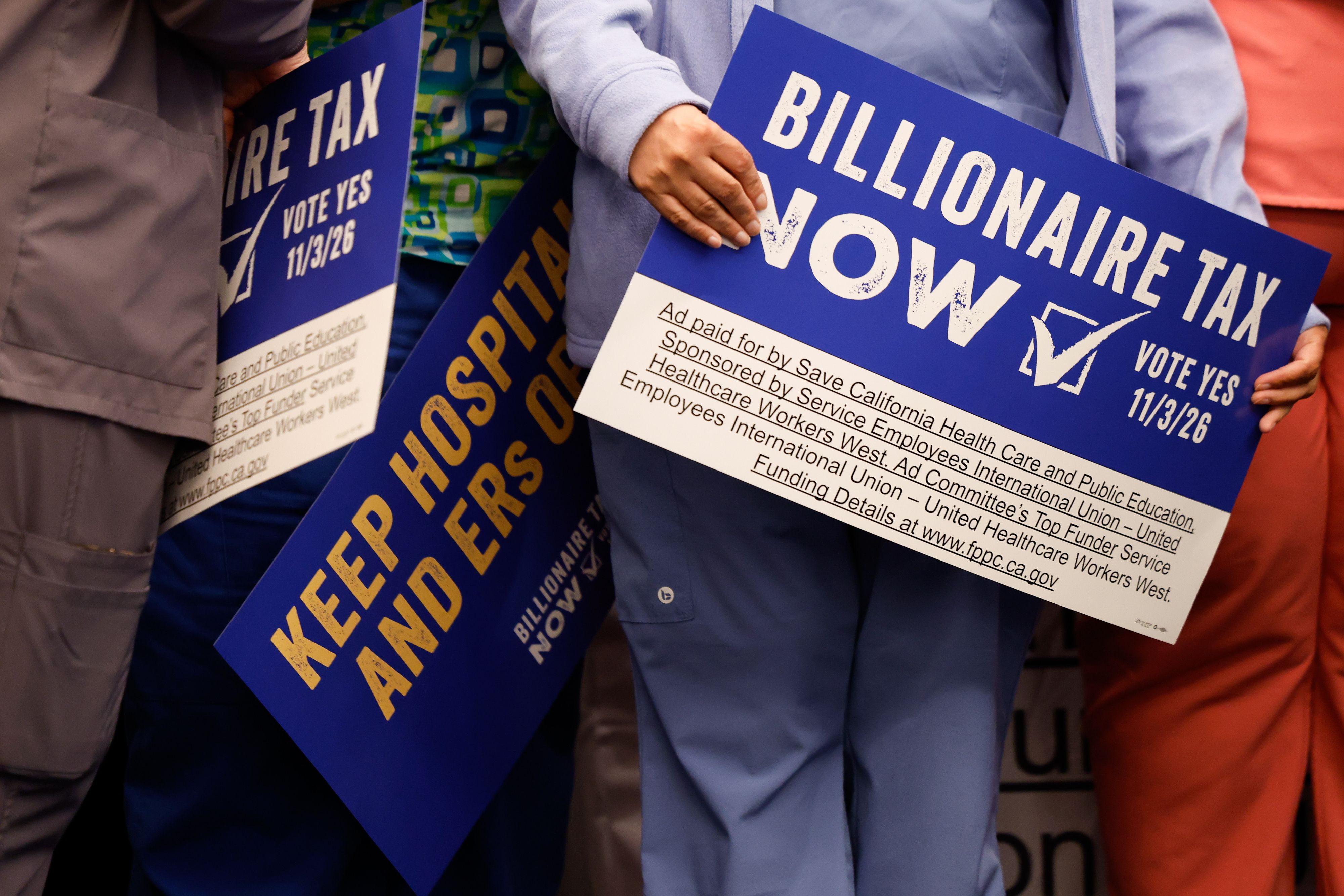 Supporters hold signs advocating for a billionaire tax in California yesterday.