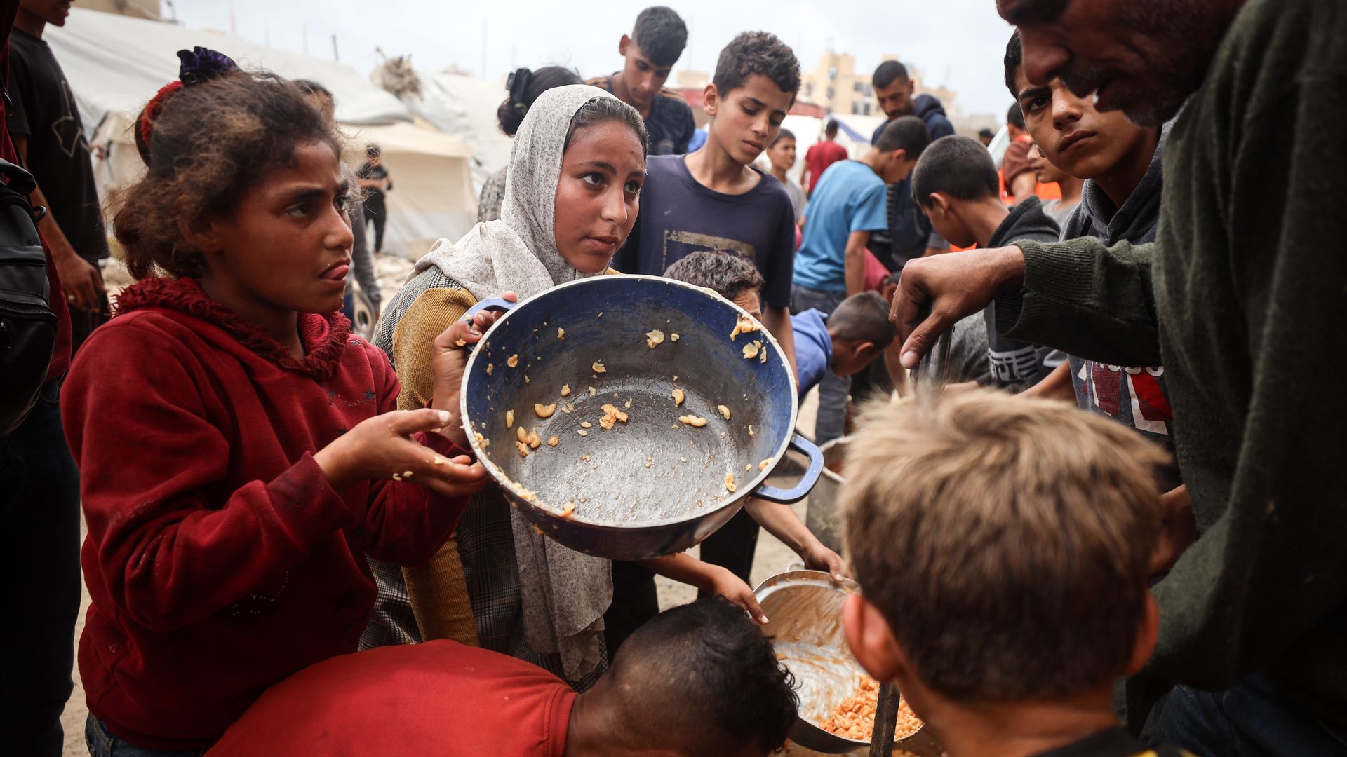 Palestinians jostle for position to get a hot meal in front of a distribution point in Gaza City.