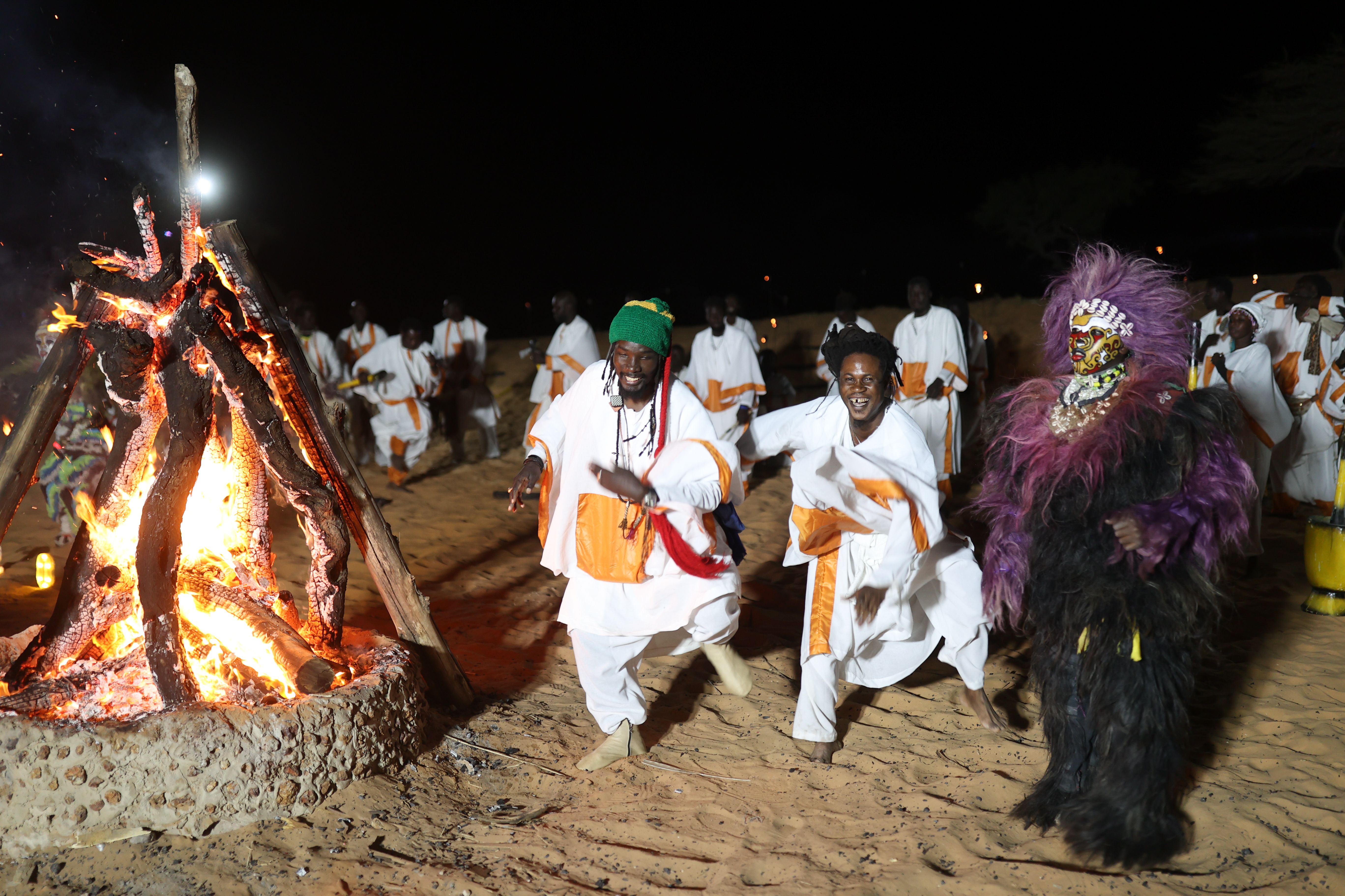  Traditional dancers with torches dance around the burning papers and play traditional instruments as they celebrate the New Year's eve in Lompoul, 180 kilometers from Dakar, Senegal on December 31, 2024.