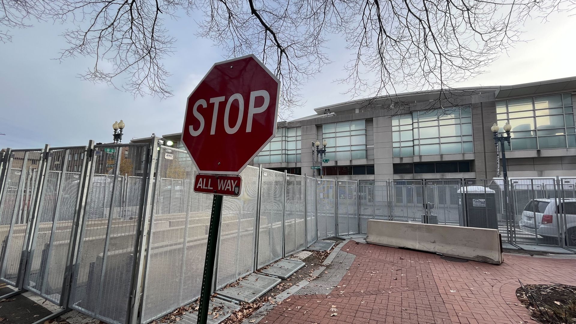 Stop sign in foreground with convention center fenced off in background