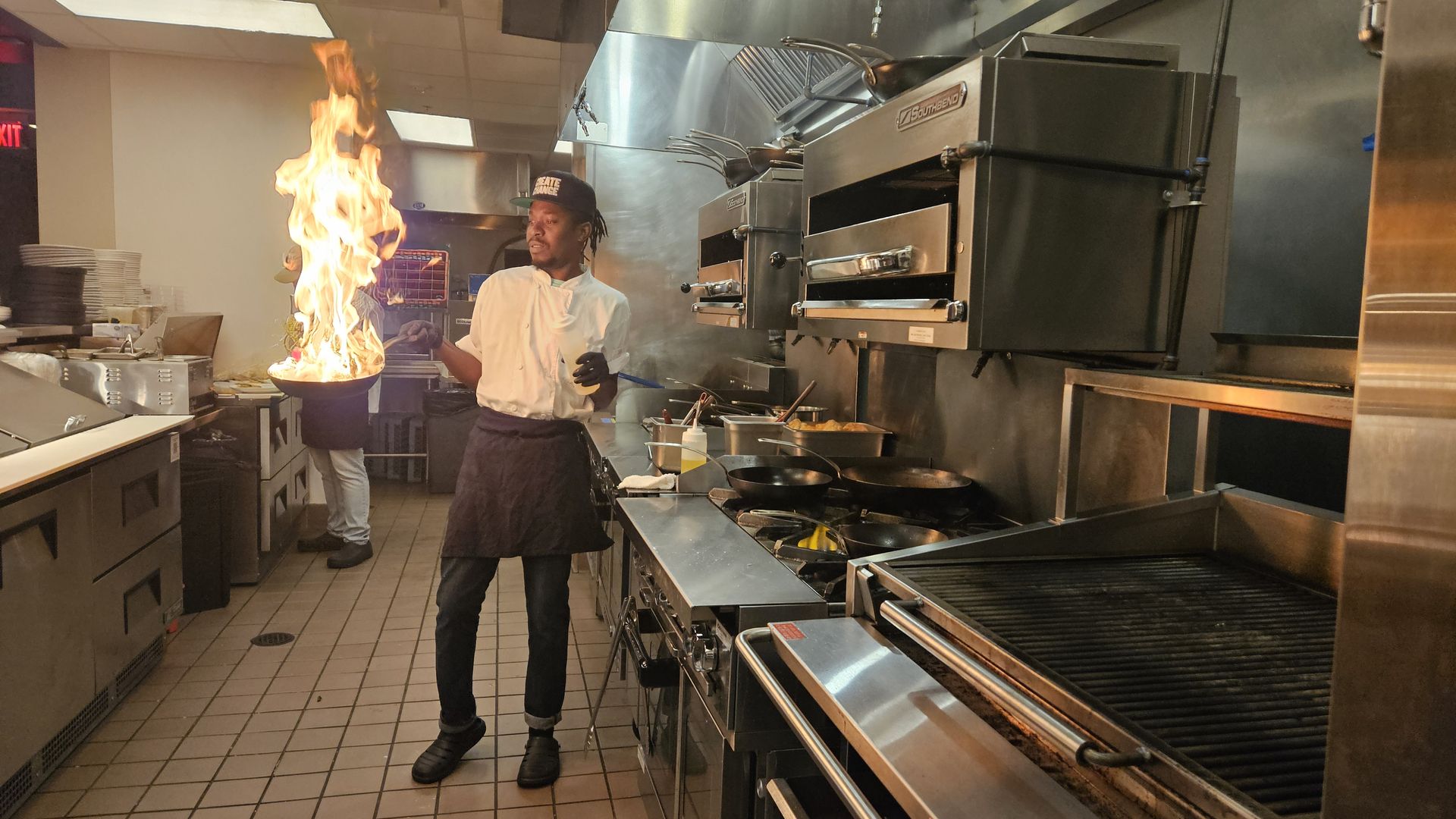 A teen pan sears a steak at Cafe Momentum.