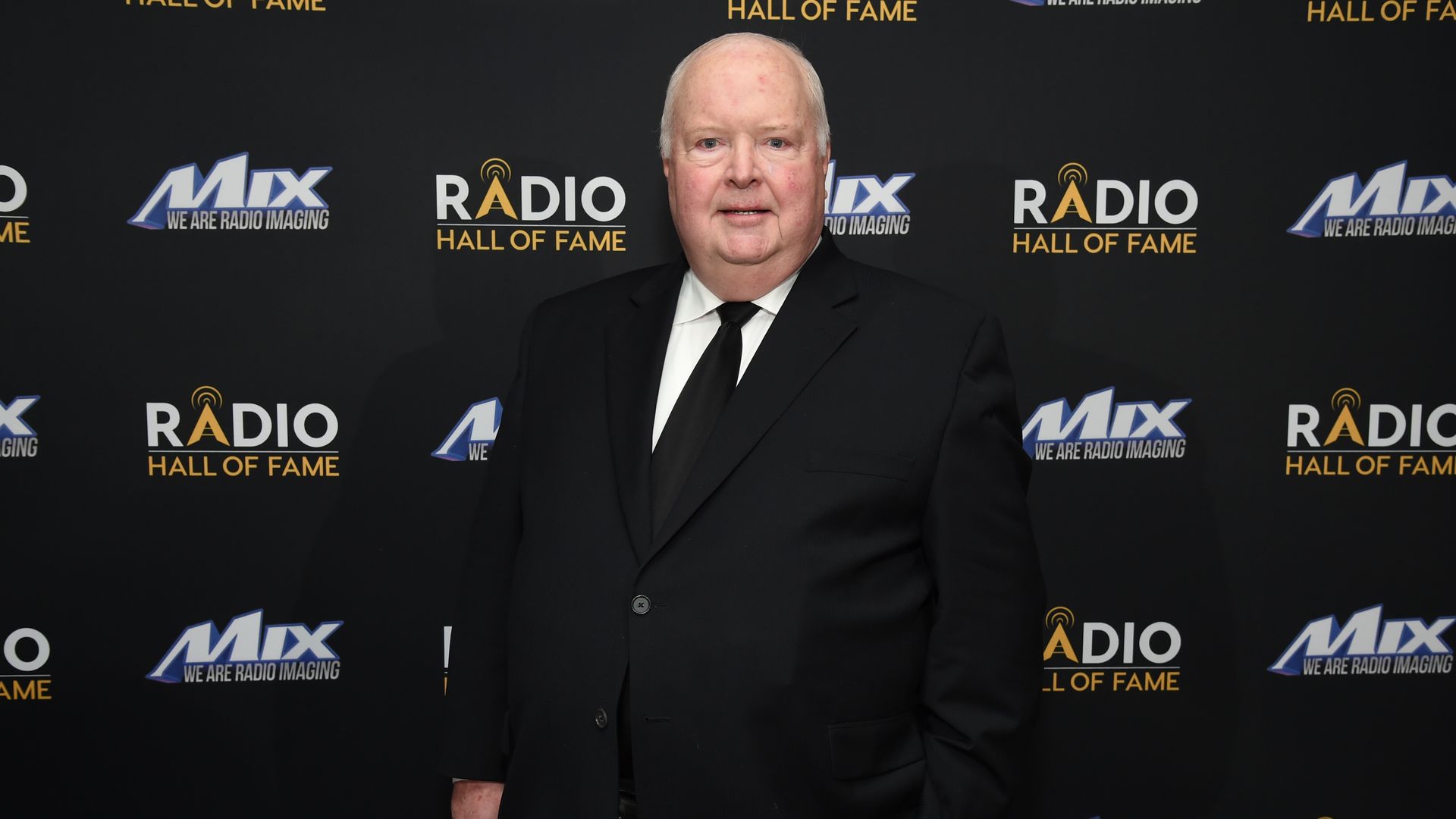 Photo of a man posing for camera at event. 