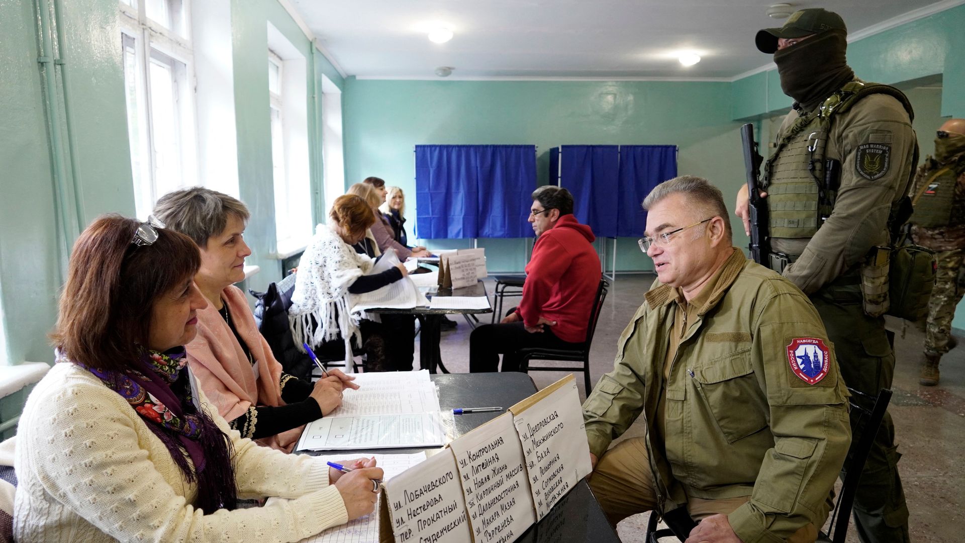 Konstantin Ivashchenko (3R), former CEO of the Azovmash plant and appointed pro-Russian mayor of Mariupol, visits a polling station as people vote in a referendum in Mariupol on September 27, 2022. -