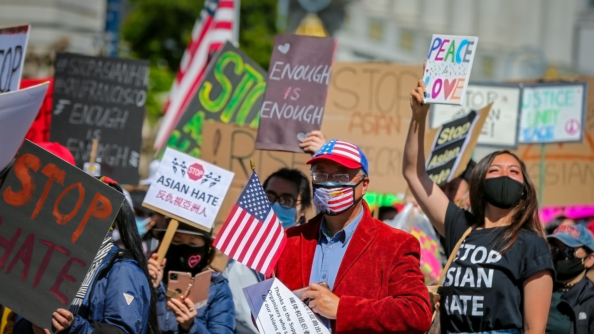 A crowd of people holding signs that read "Enough is enough" and "Stop hate"