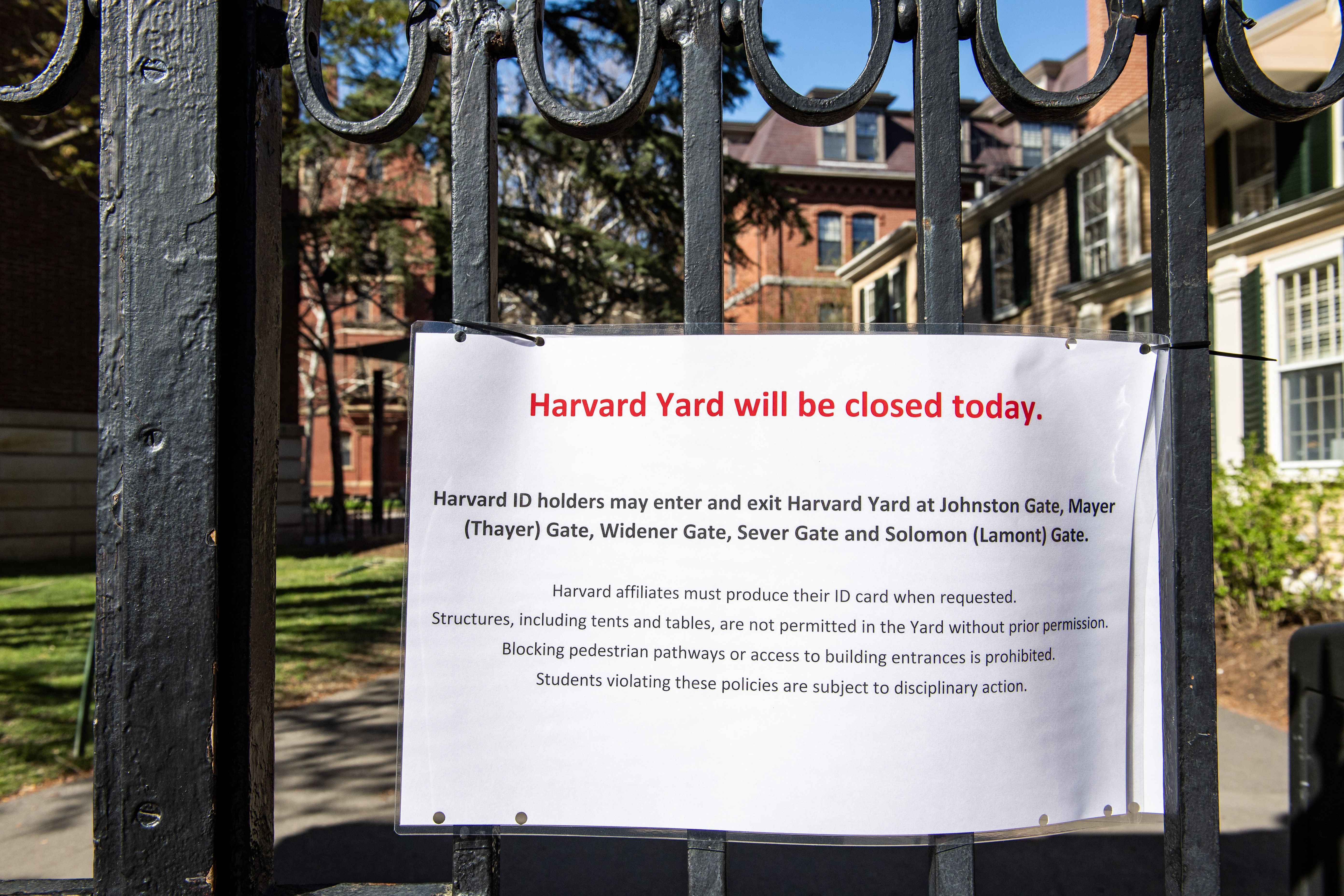 A sign on a gate at Harvard stating that Harvard Yard is closed. 