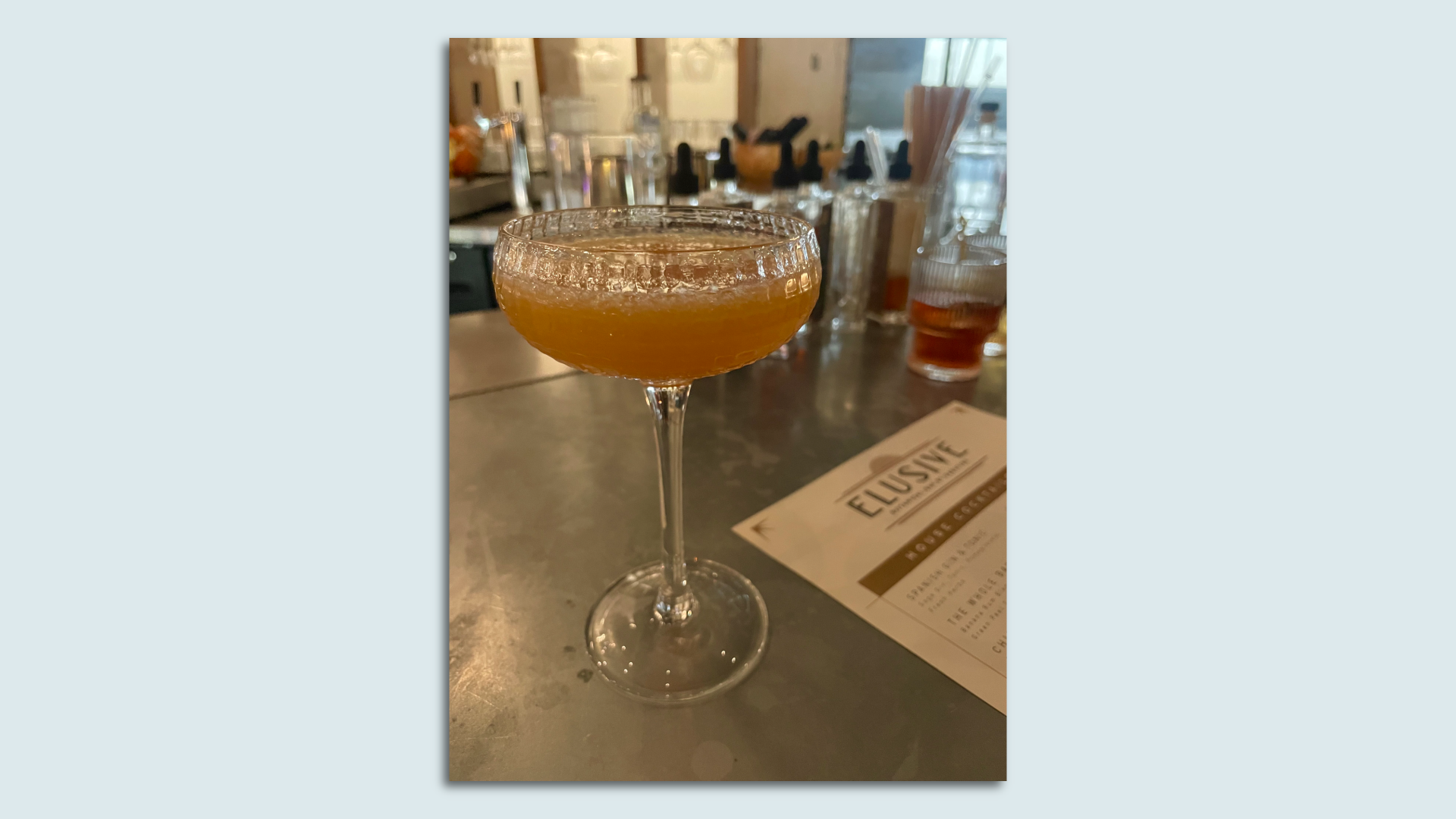 A yellow cocktail on a table.