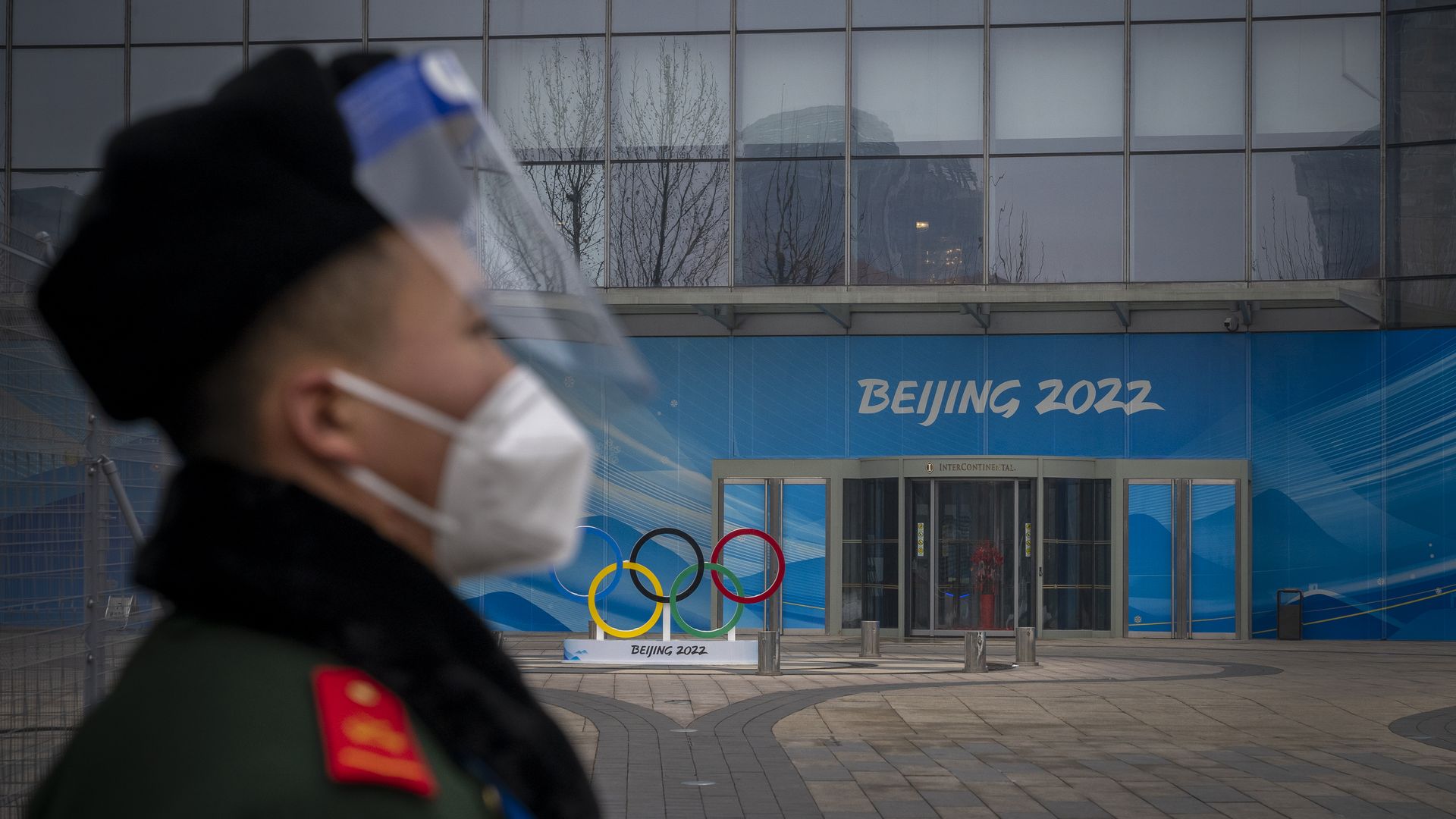 A security guard stands behind a barricade in an area not accessible to the general public, that will host Beijing 2022 Winter Olympics at Olympic Park on January 23