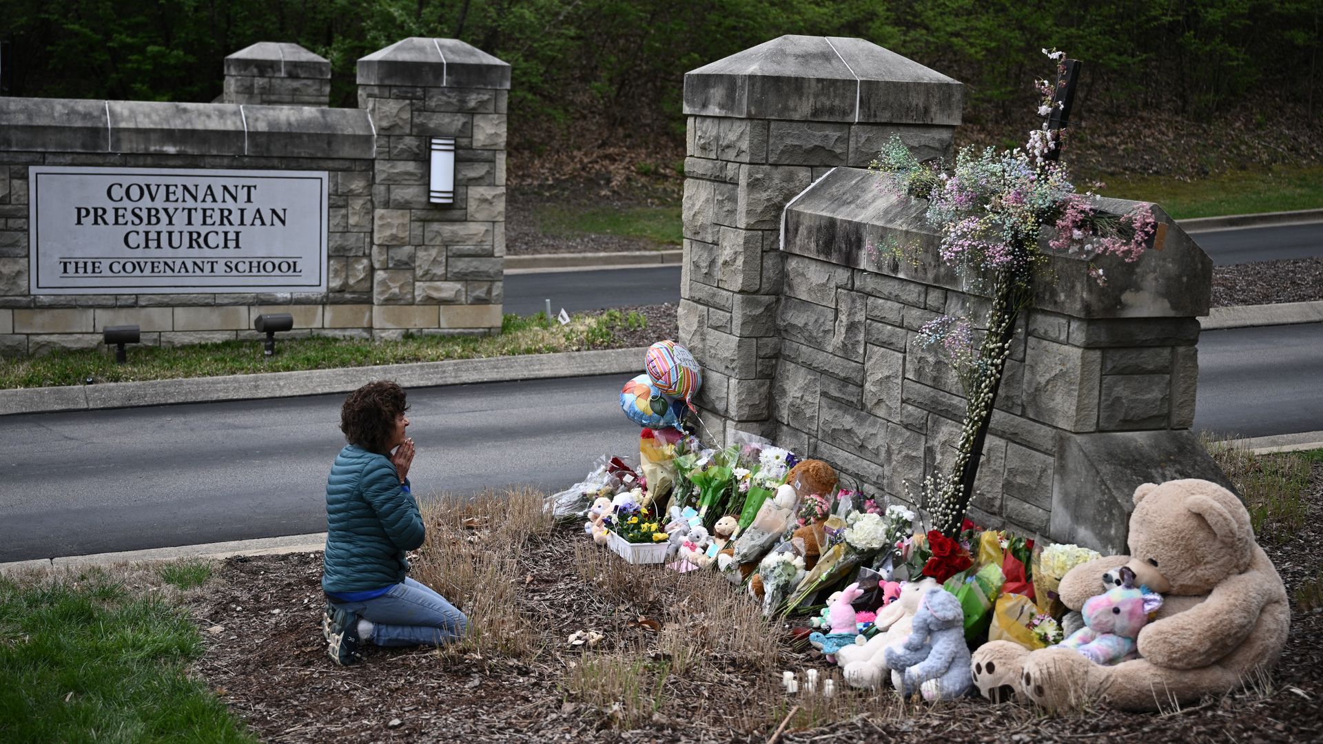 Robin Wolfenden prays at a makeshift memorial for victims outside the Covenant School building at the Covenant Presbyterian Church following a shooting, in Nashville, Tennessee, on March 28, 2023. A heavily armed former student killed three young children and three staff.