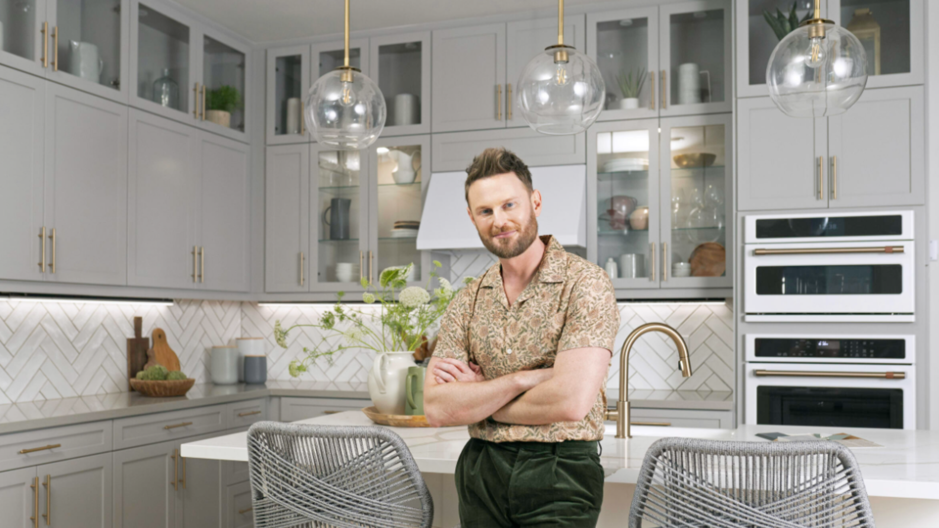 A man standing in front of a kitchen island. 