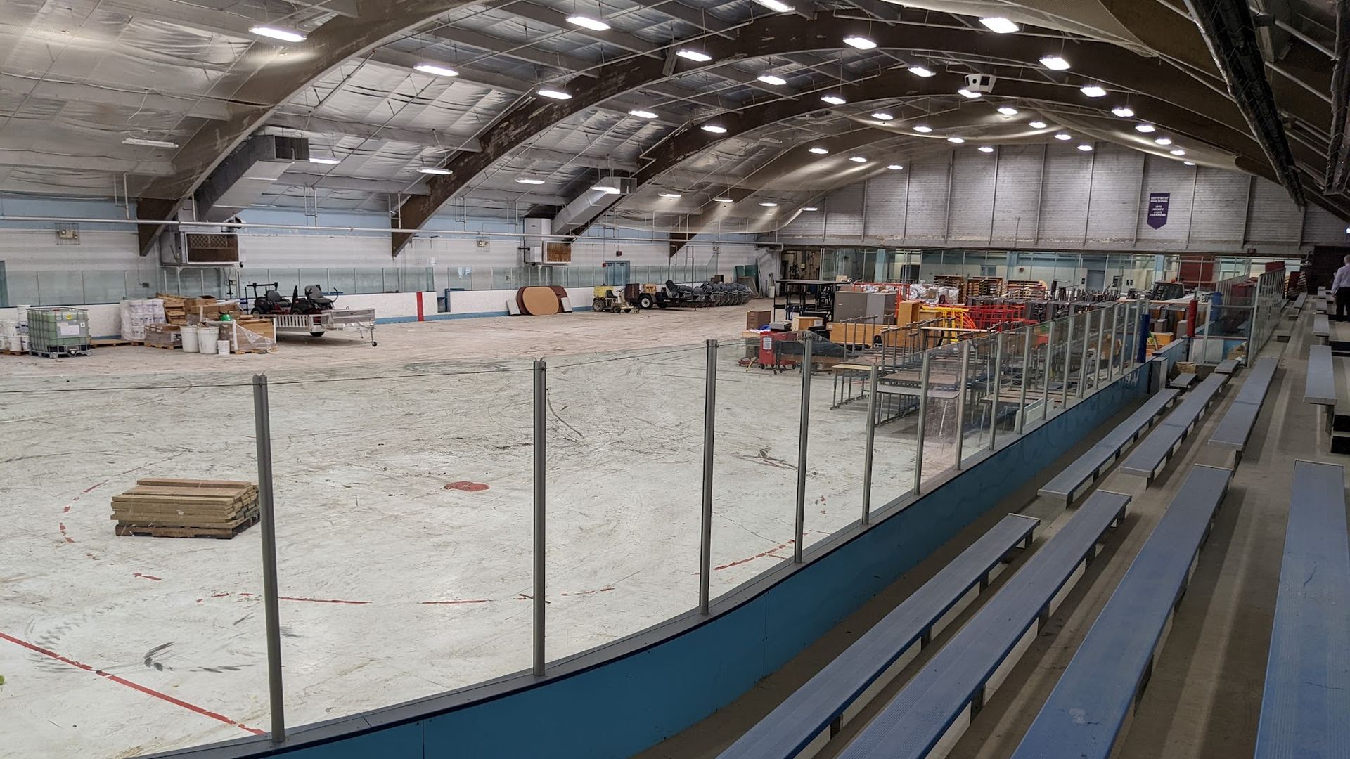 A derelict hockey rink filled with old chairs.