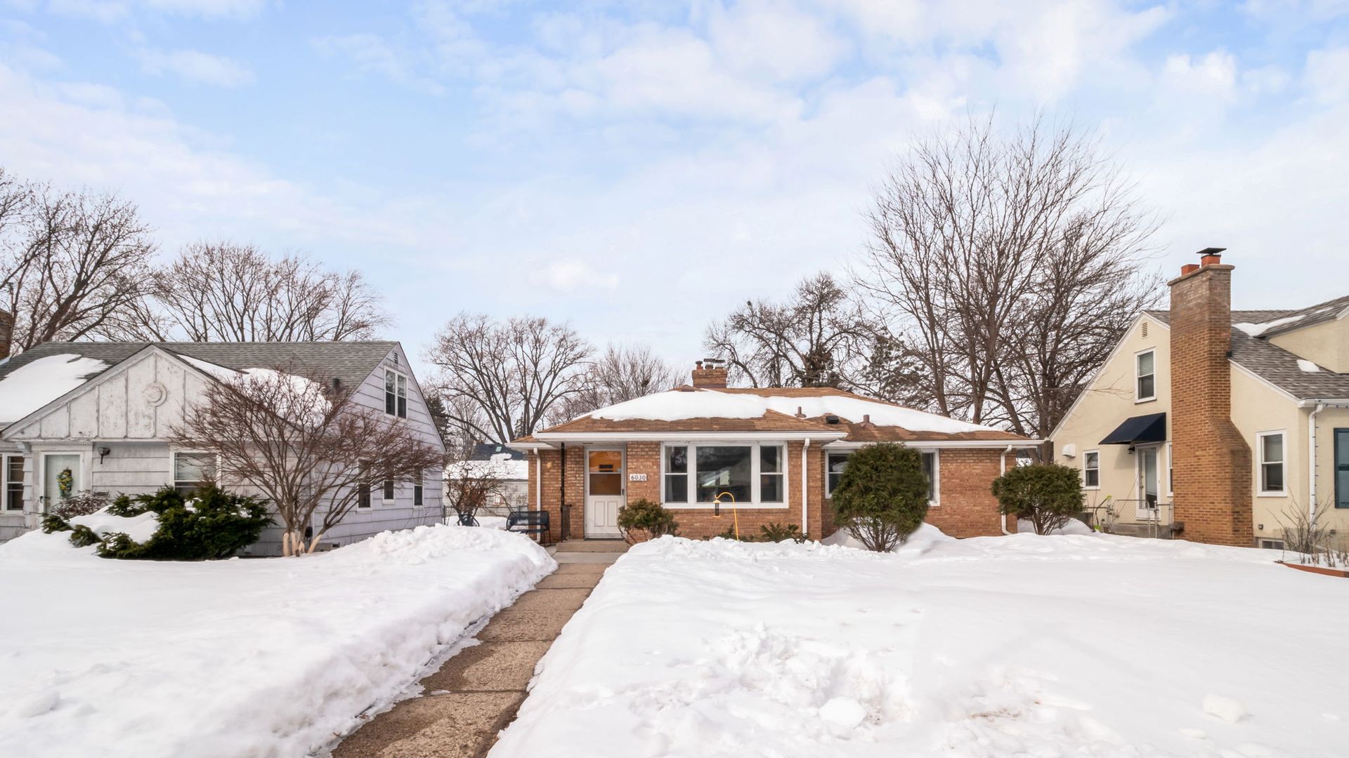 exterior view of a snowy brick rambler home