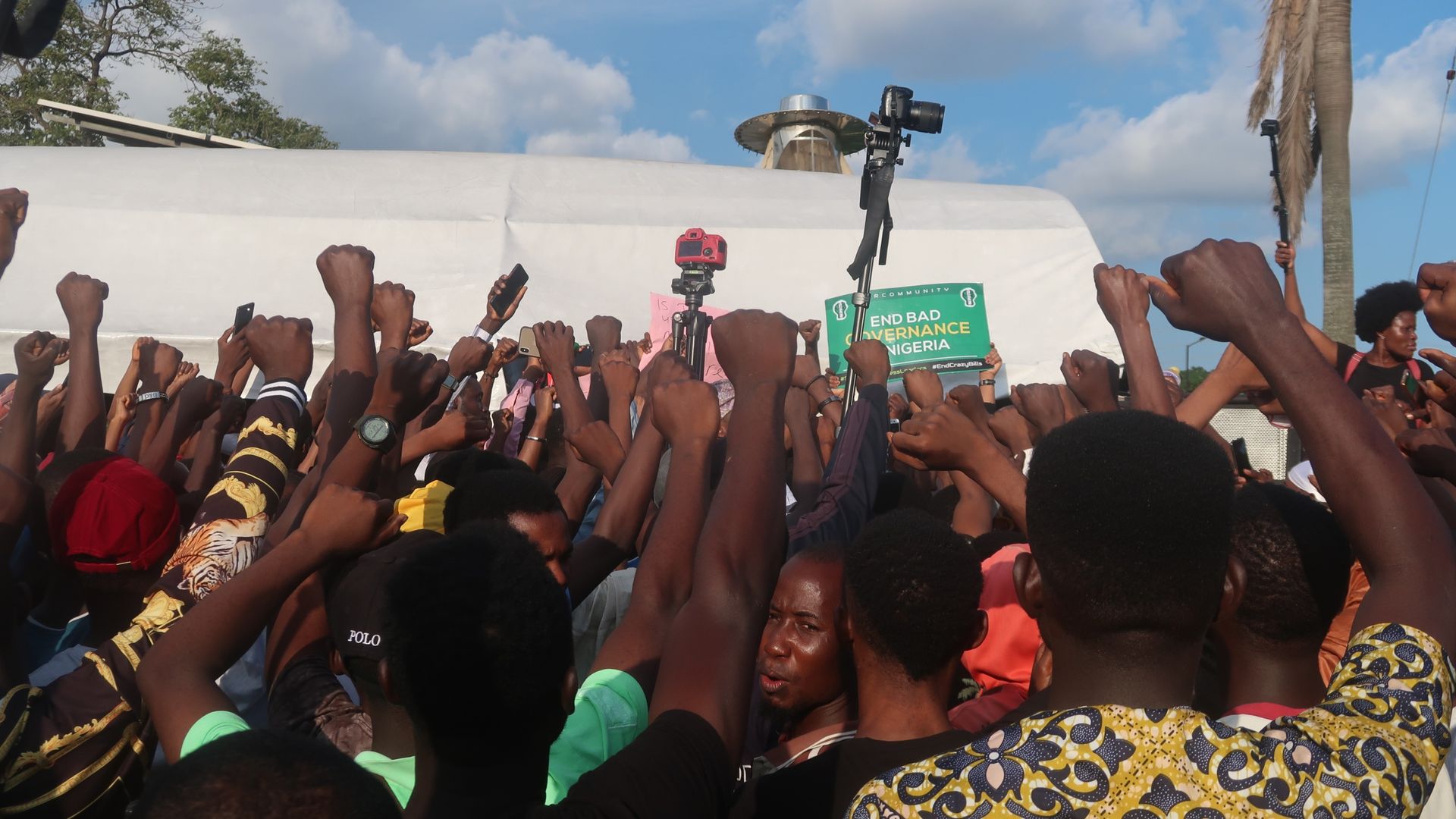 A crowd of Nigerian youths raise their arms against police brutality