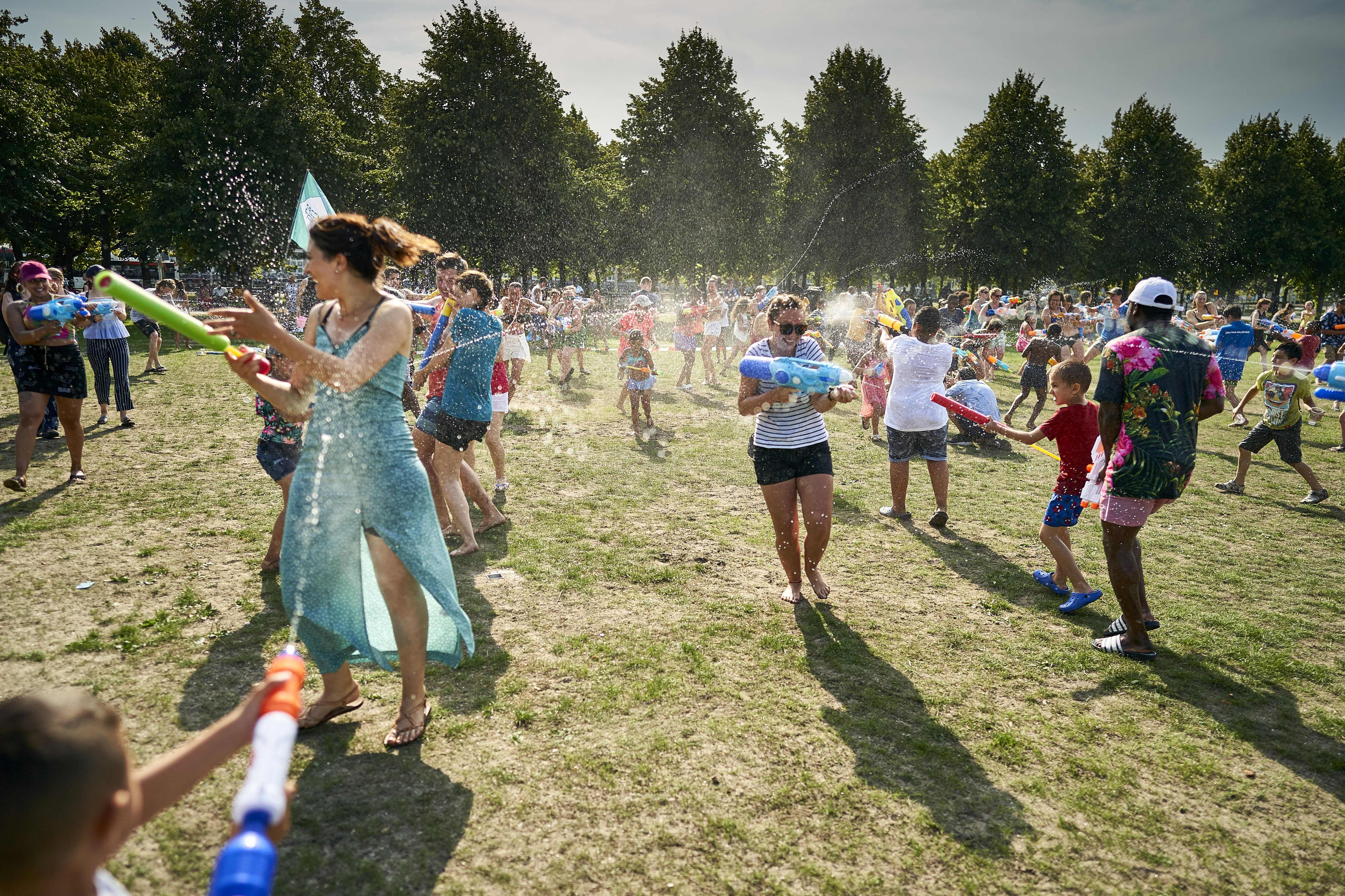 People cool off as they enjoy a water fight on the Malieveld, in The Hague city center, on July 24