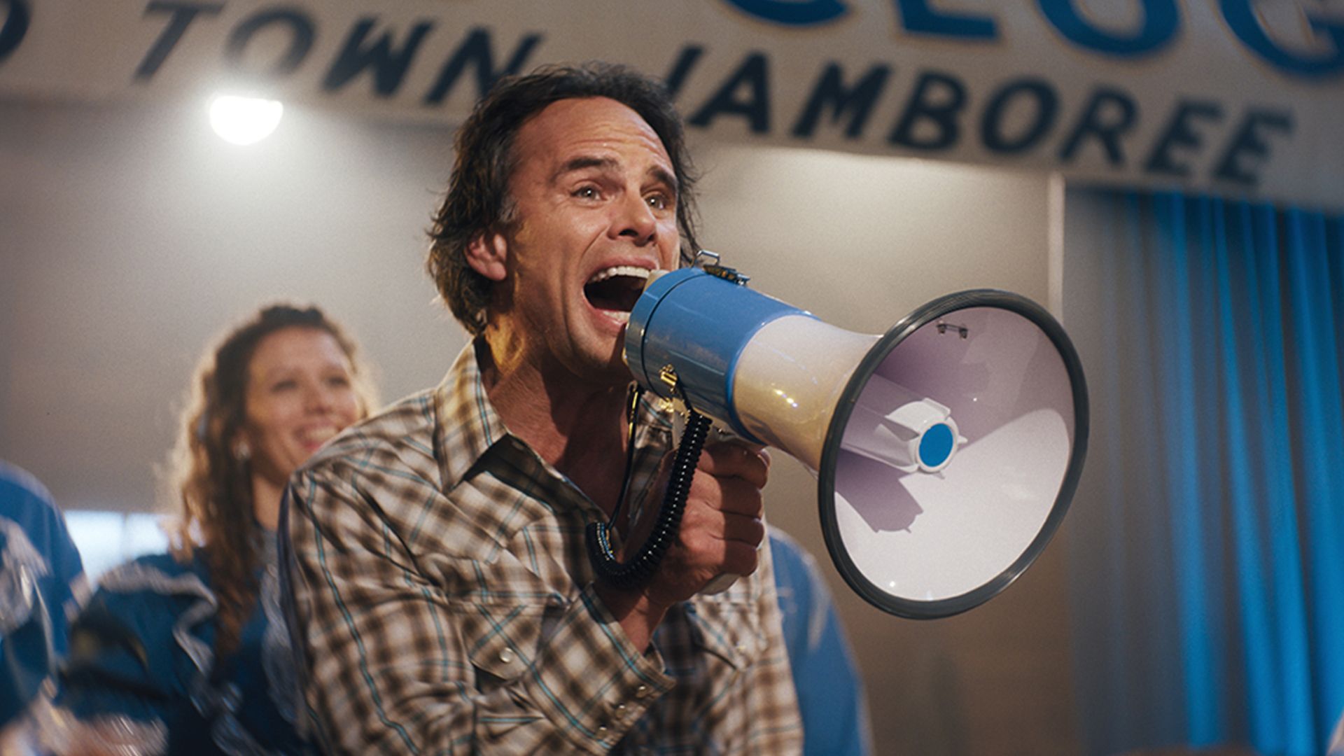 A photo of Walton Goggins shouting into a megaphone.