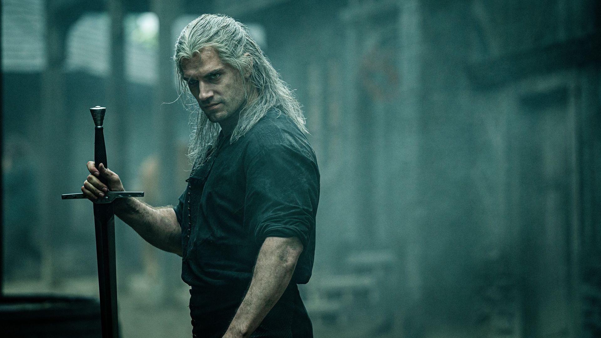 A man with long white hair holds a sword while looking toward the camera