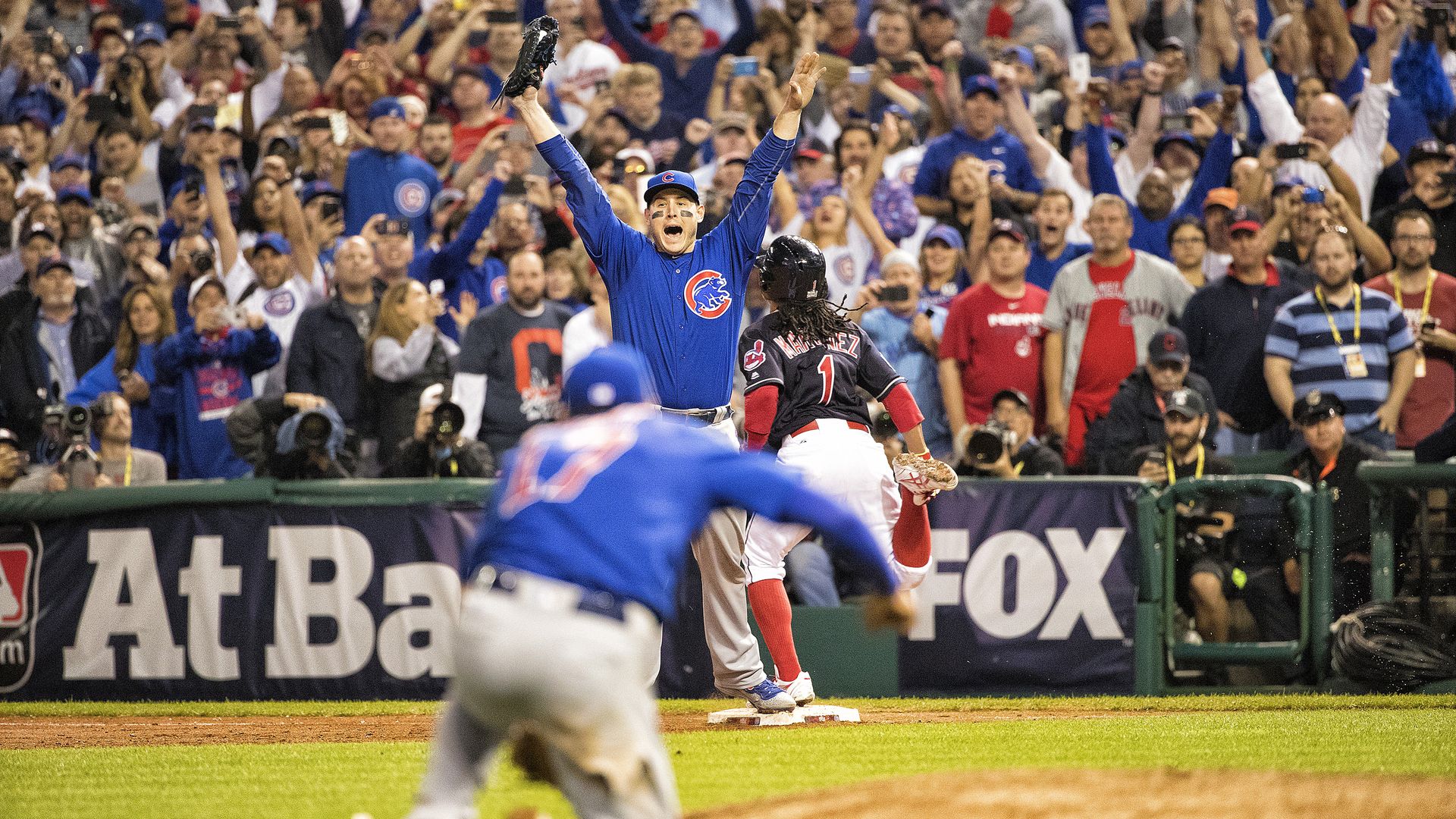 Photo of a baseball player raising his hands in celebration. 