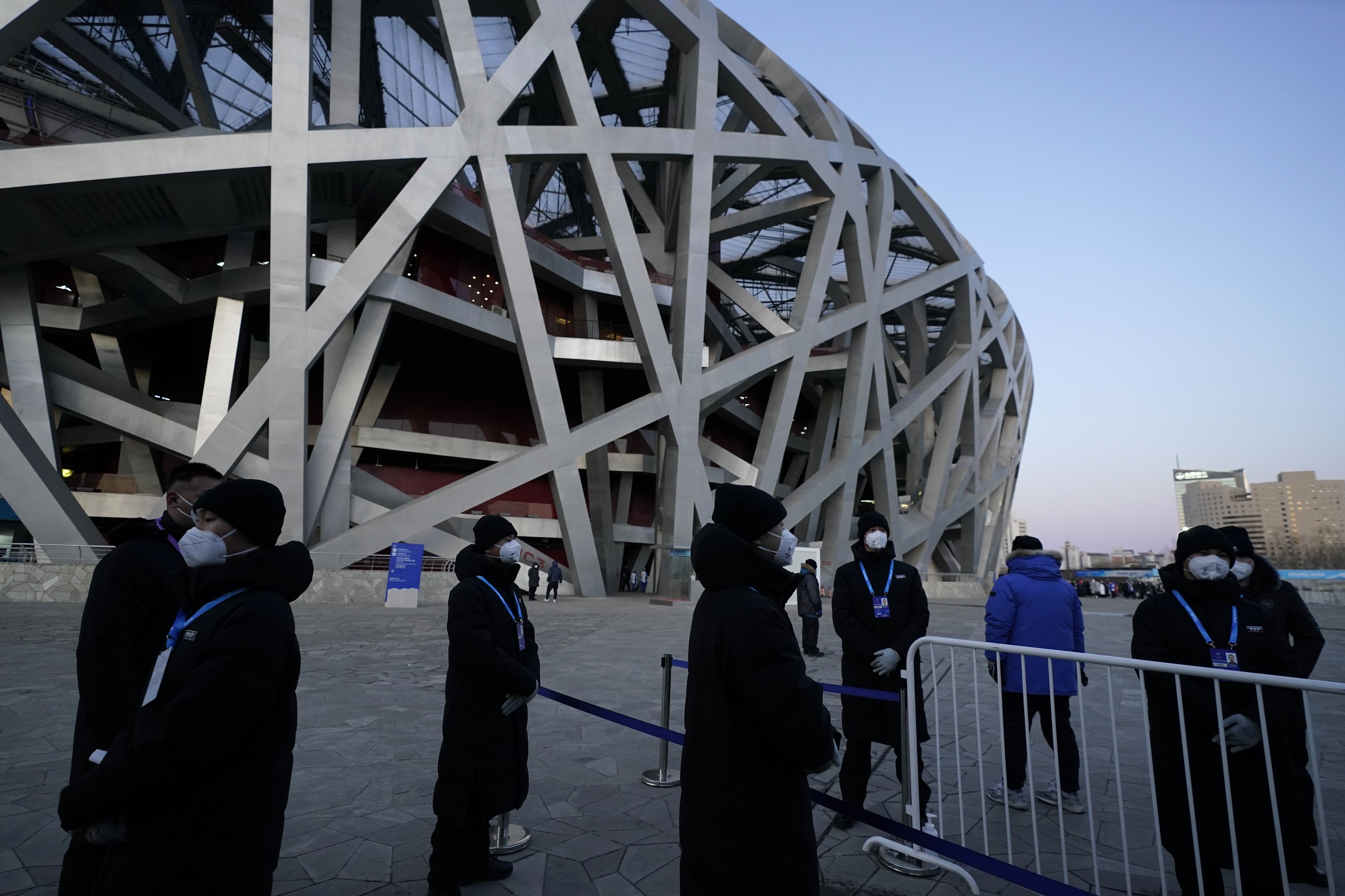 Security stand outside the National Stadium known as the Bird's Nest ahead of the opening ceremony of the 2022 Winter Olympics.