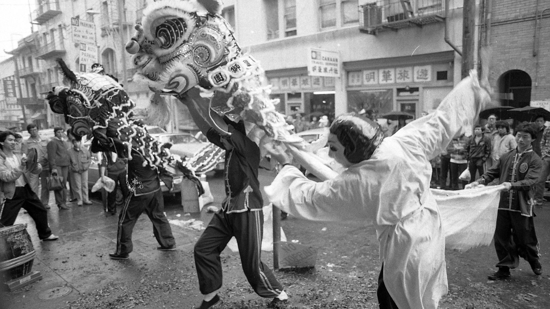Black-and-white photo of Chinese people dancing in dragon costumes