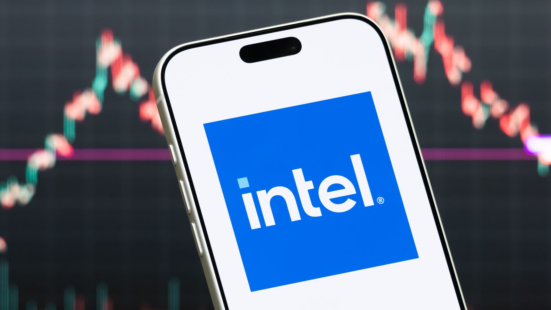 Intel logo on a smart phone, with a stock chart in background.