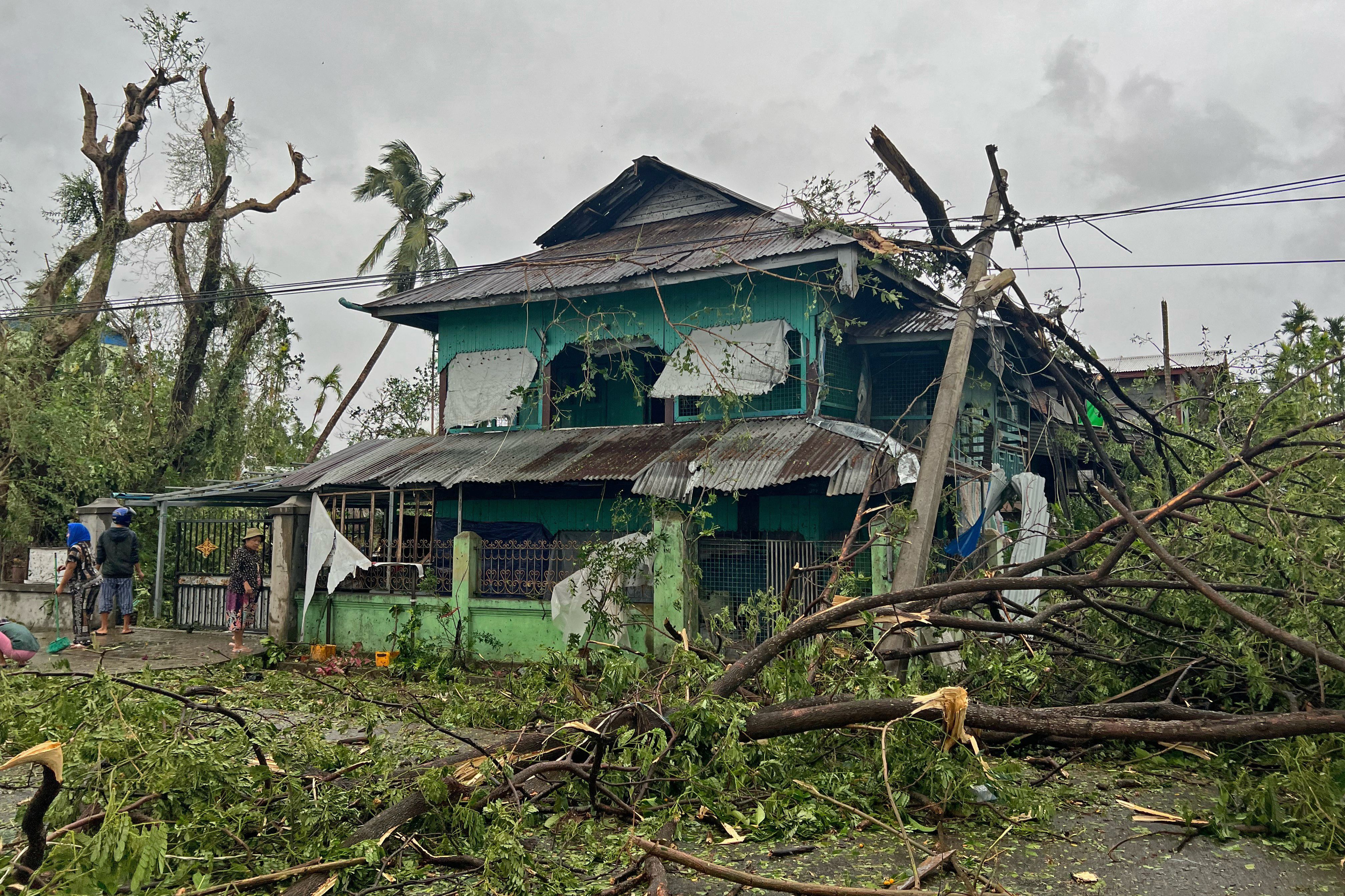 Local residents check the damages after Cyclone Mocha crashed ashore, in Kyauktaw in Myanmar's Rakhine state on May 14,