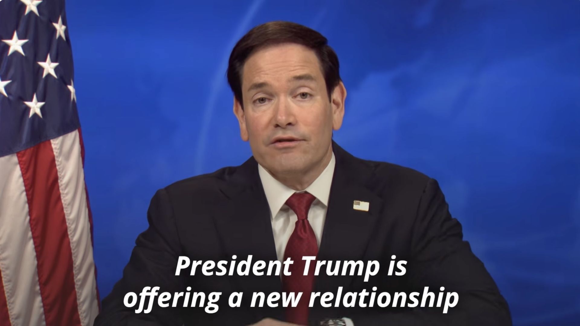 A screenshot from Marco Rubio's speech. A white caption reads "President Trump is offering a new relationship."