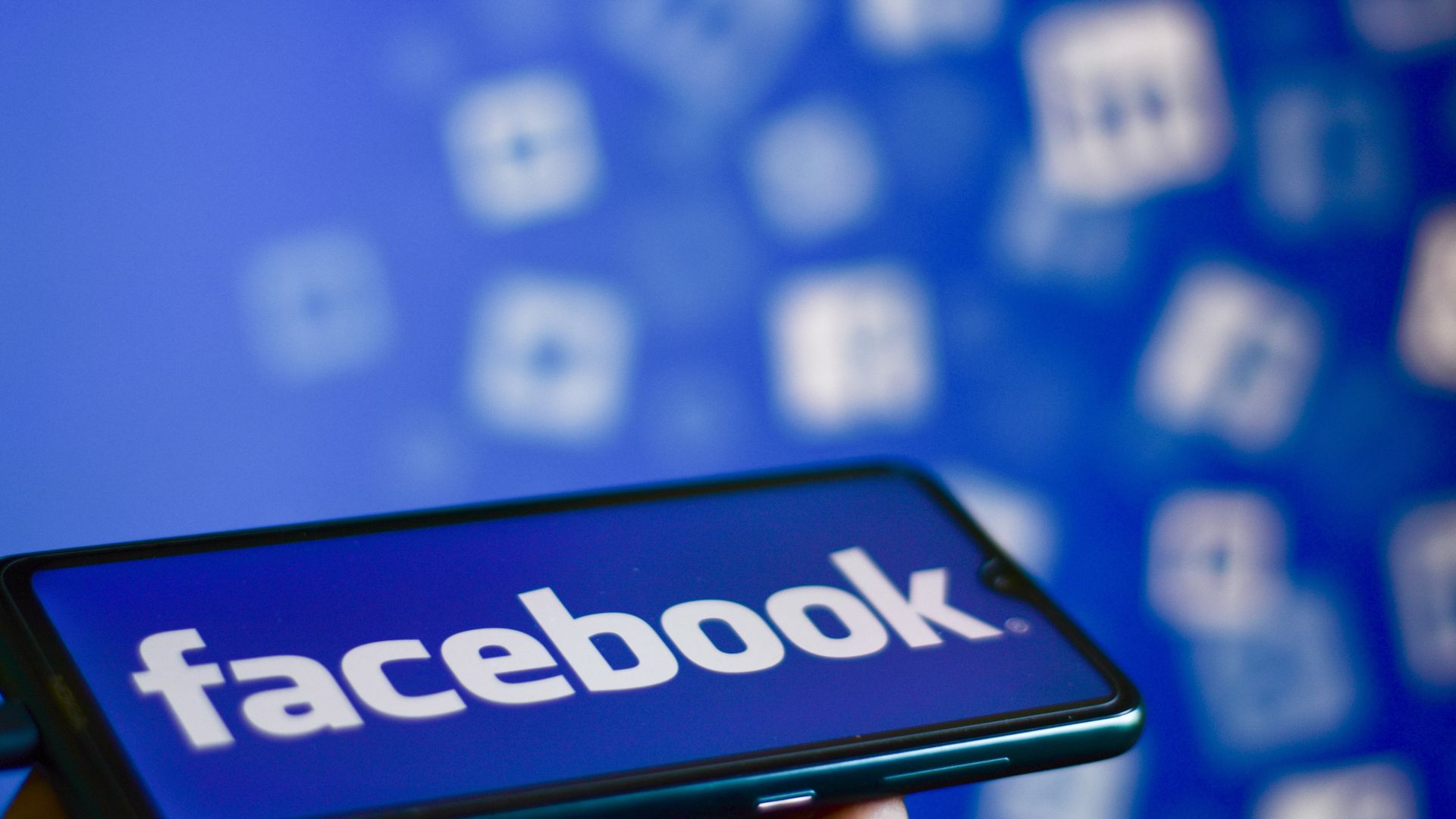 A Facebook logo is displayed on a smartphone.