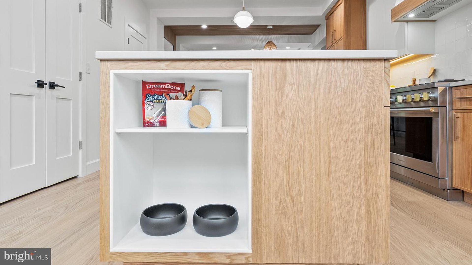 dog food and water bowls tucked into a kitchen island