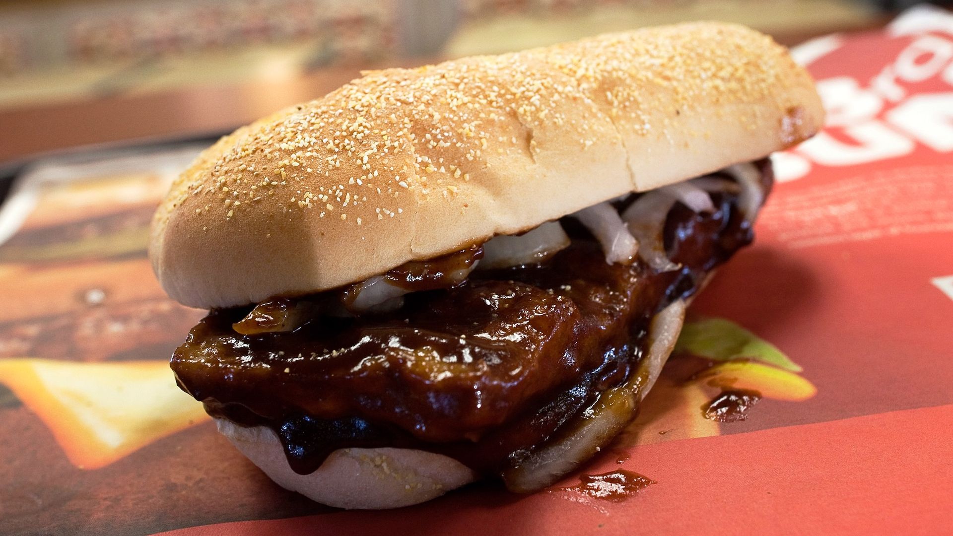 A McDonald's McRib sandwich on bun with onions.