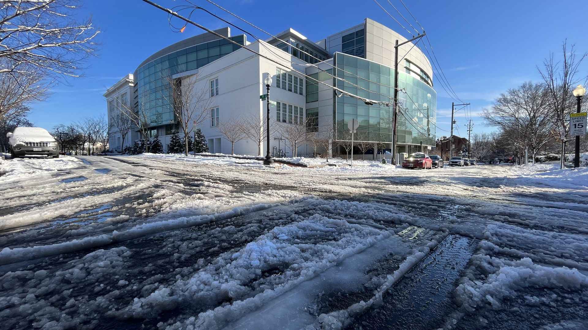 A snow-covered intersection with Duke Ellington School of the Arts in the background