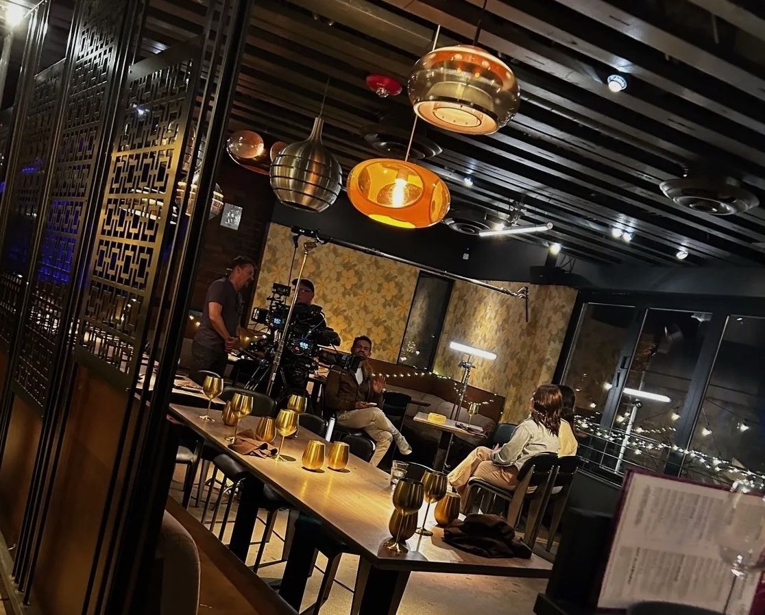 A restaurant with low lightning and golden wine glasses that appear to be a part of the love is blind show