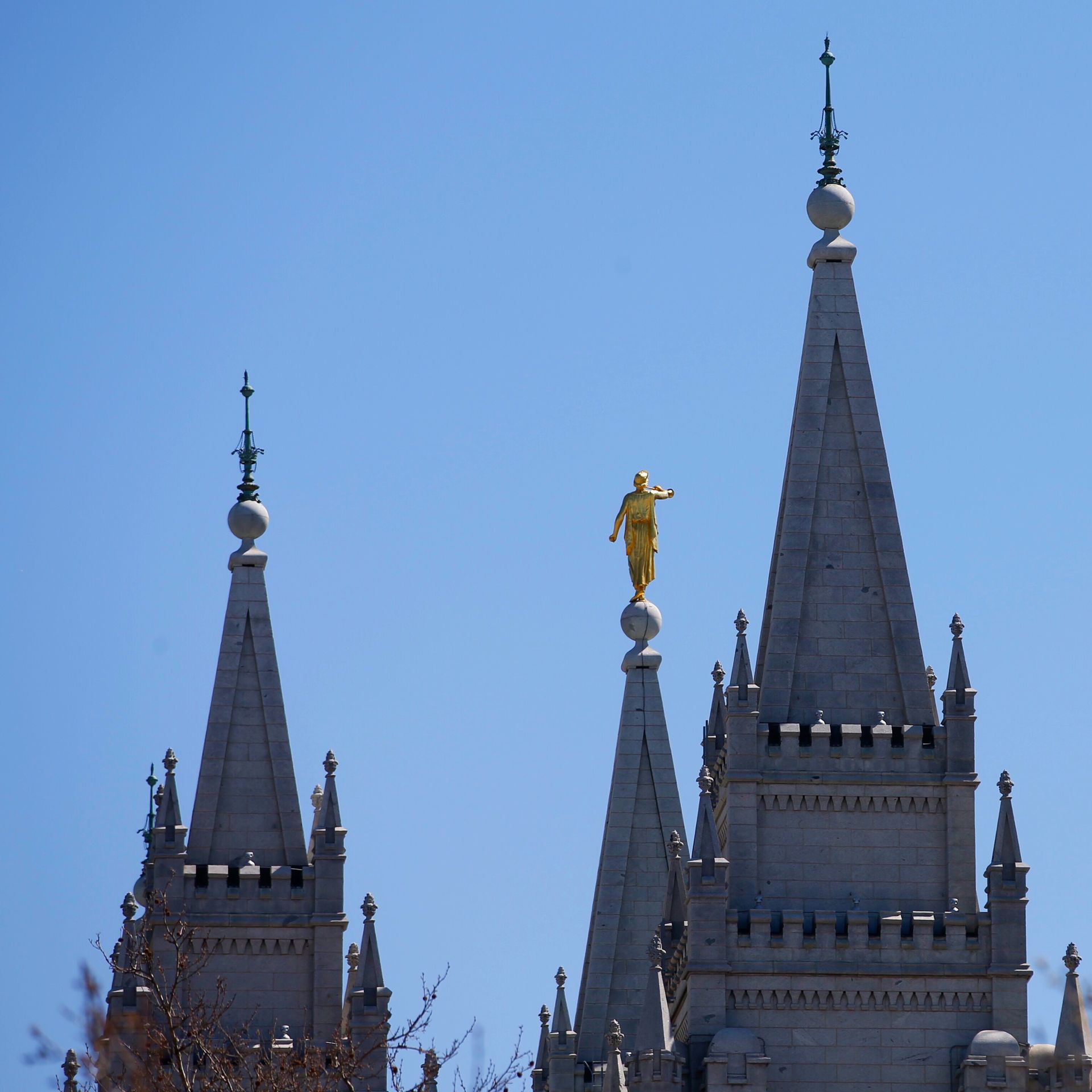 The steeples at the Salt Lake City temple appear before a blue sky.