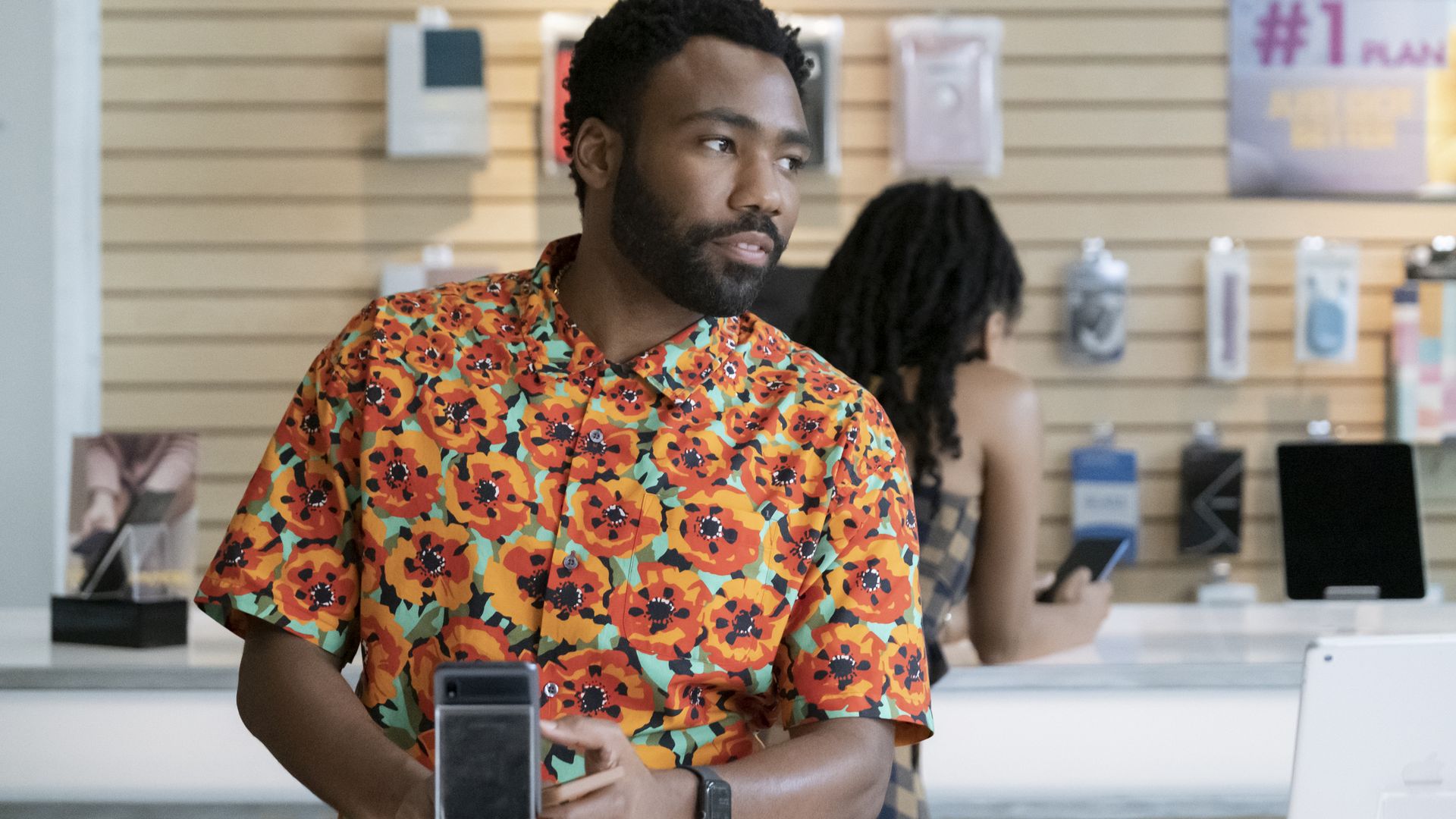 A photo of Donald Glover wearing a colorful shirt in a store in the TV show Atlanta