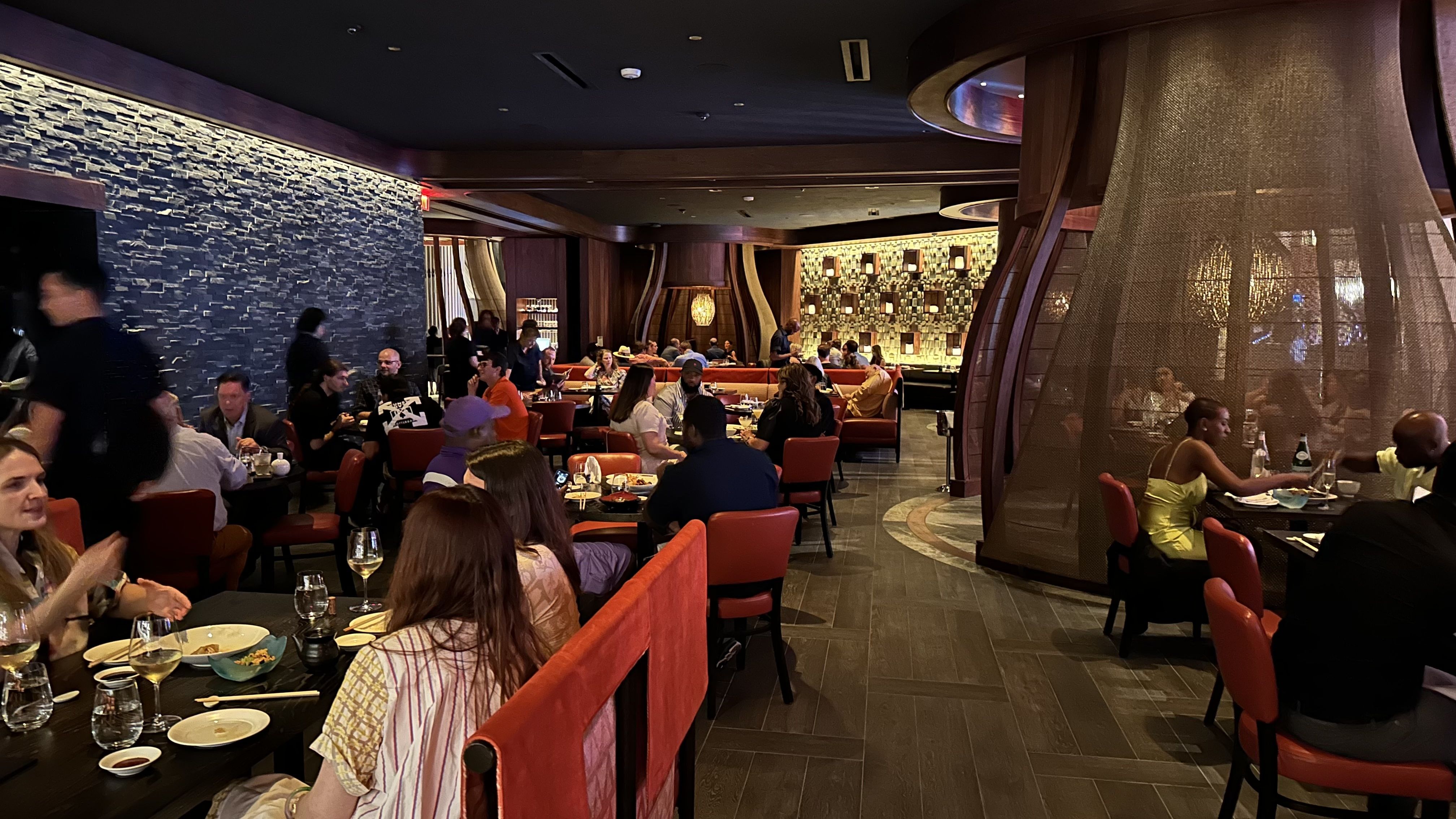 Diners eat inside a busy restaurant.