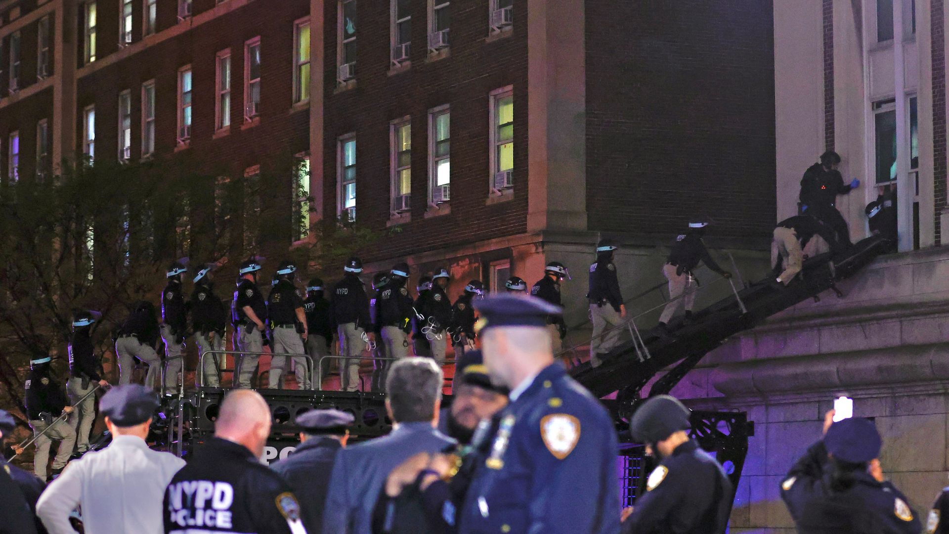 NYPD officers in riot gear break into a building at Columbia University, where pro-Palestinian students are barricaded inside a building and have set up an encampment, in New York City on April 30