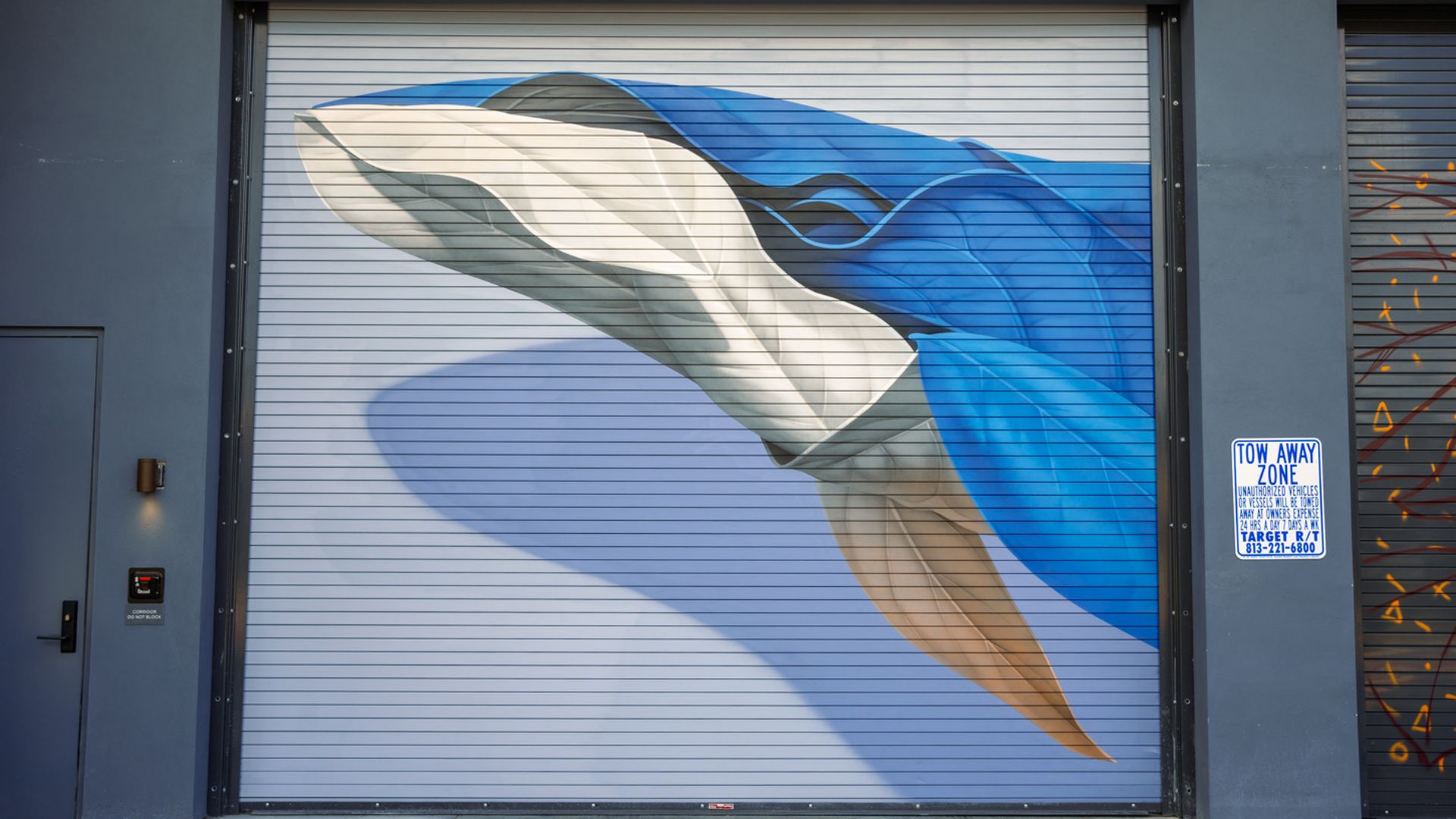 A photo of a mural of a whale on a parking garage.