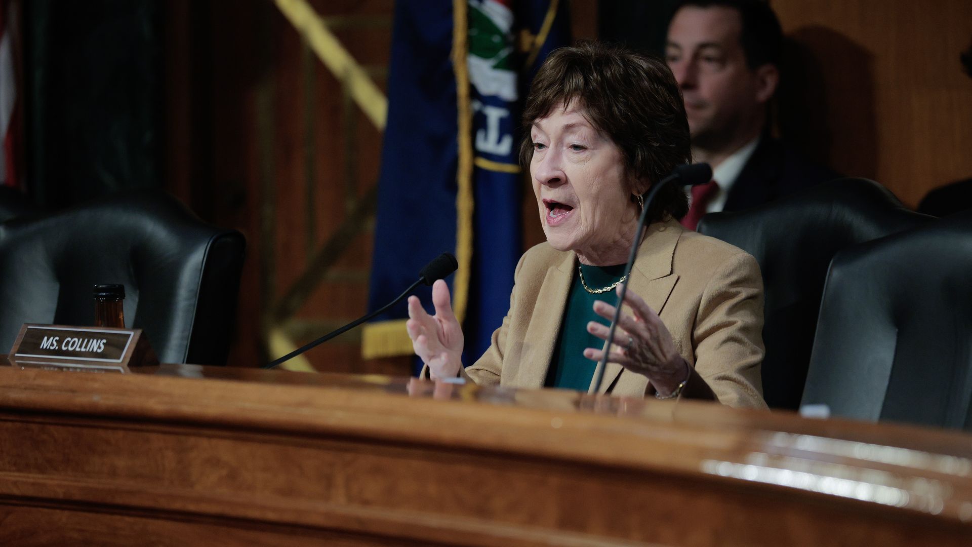 Sen. Susan Collins speaks into a microphone as U.S. Army Lt. Gen. Joshua Rudd sits at a witness table during a Senate confirmation hearing.