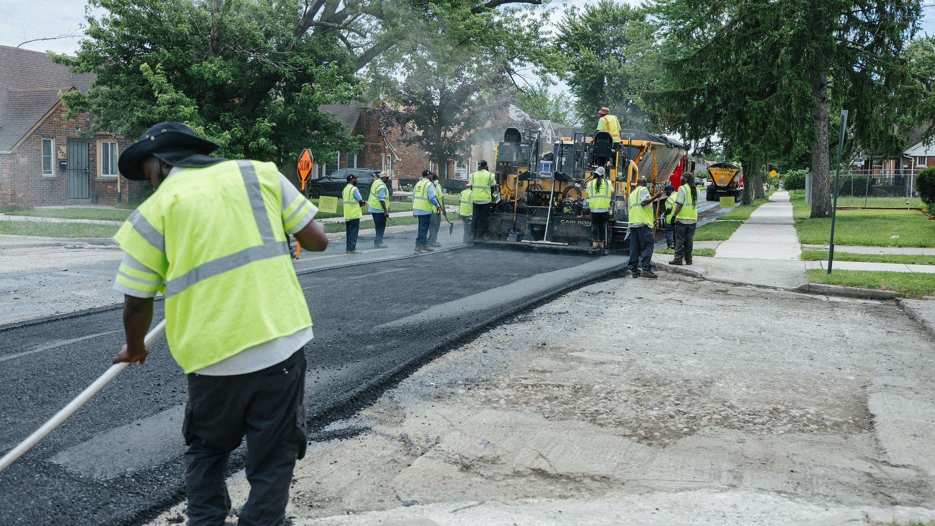 Workers repave a neighborhood road