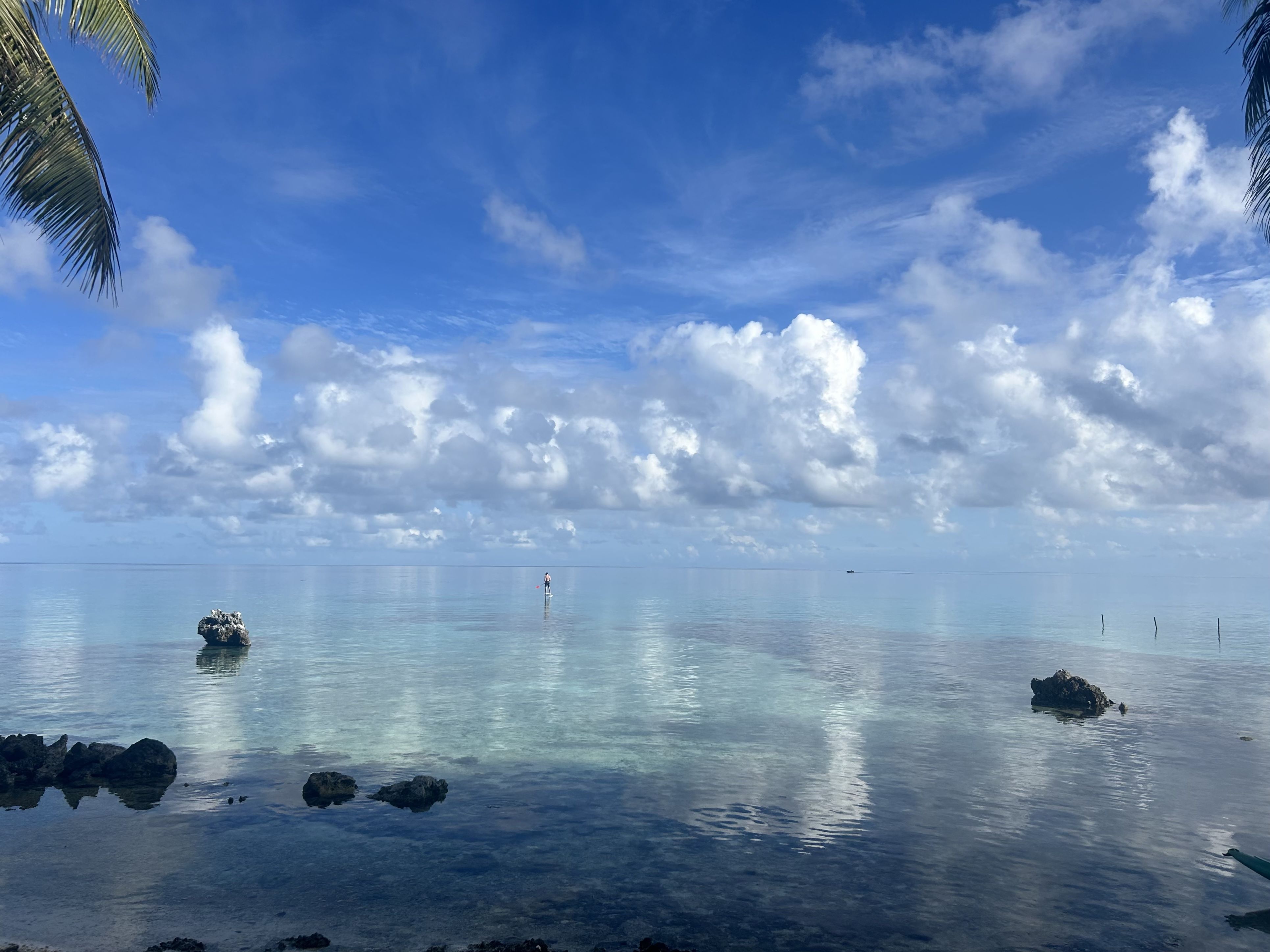 A boy paddleboards on cool blue water