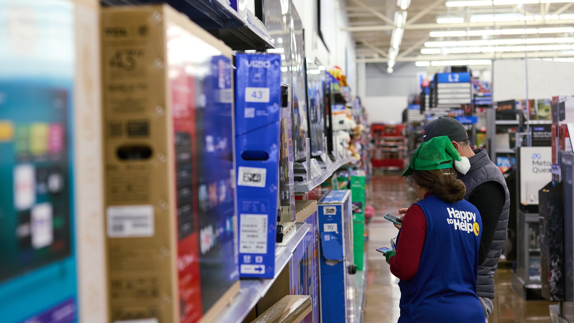 A worker assists a customer in the electronics department at a Walmart store on Black Friday in Columbus, Ohio, US, on Friday, Nov. 28, 2025.