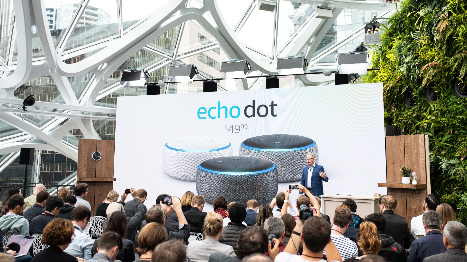 In this image, a crowd surrounds a stage that supports a large Amazon Echo Dot advertisement. 